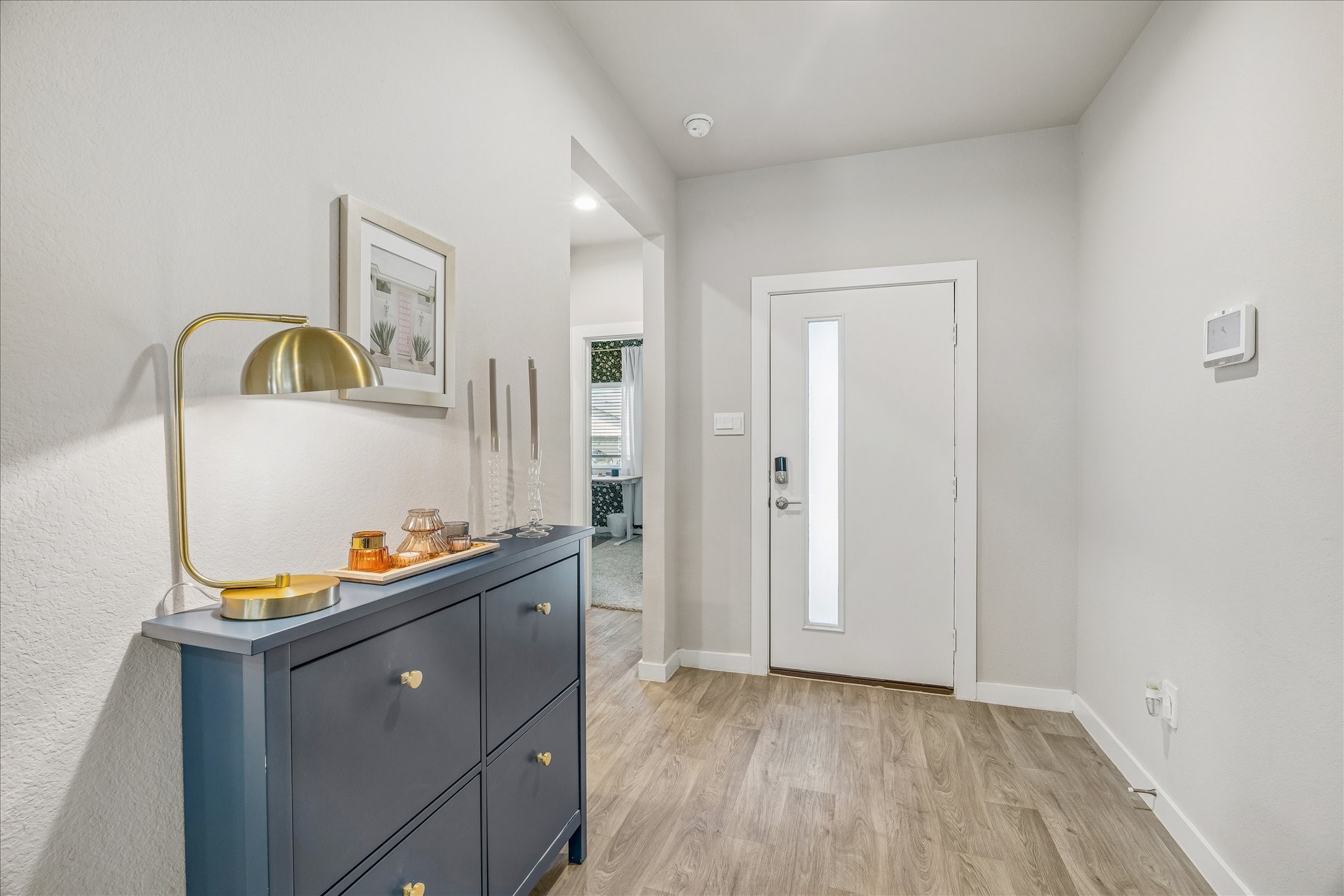 Bright entryway with neutral vinyl plank flooring. This home features a study/optional 4 bedroom to the left.
