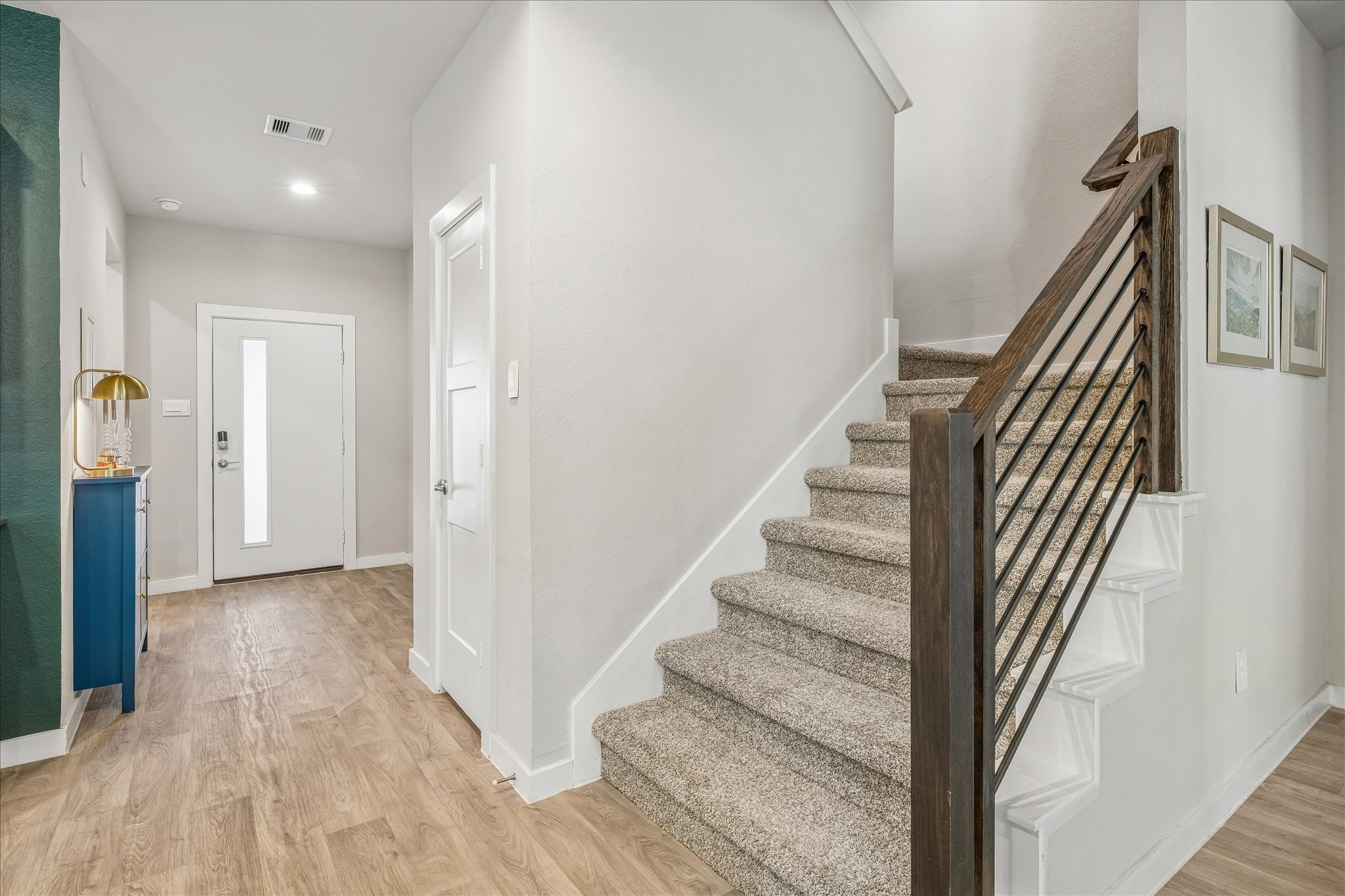 Off the entryway is the modern staircase with wrought iron detailing.