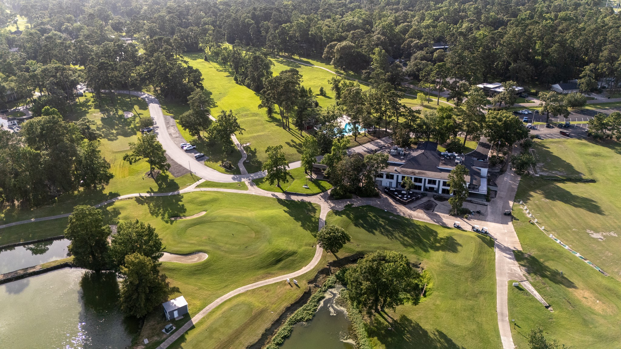 Golf club nestled amidst lush greenery, stunning views of a sprawling golf course, complete with serene water features and a charming clubhouse, perfect for leisurely days and social gatherings.