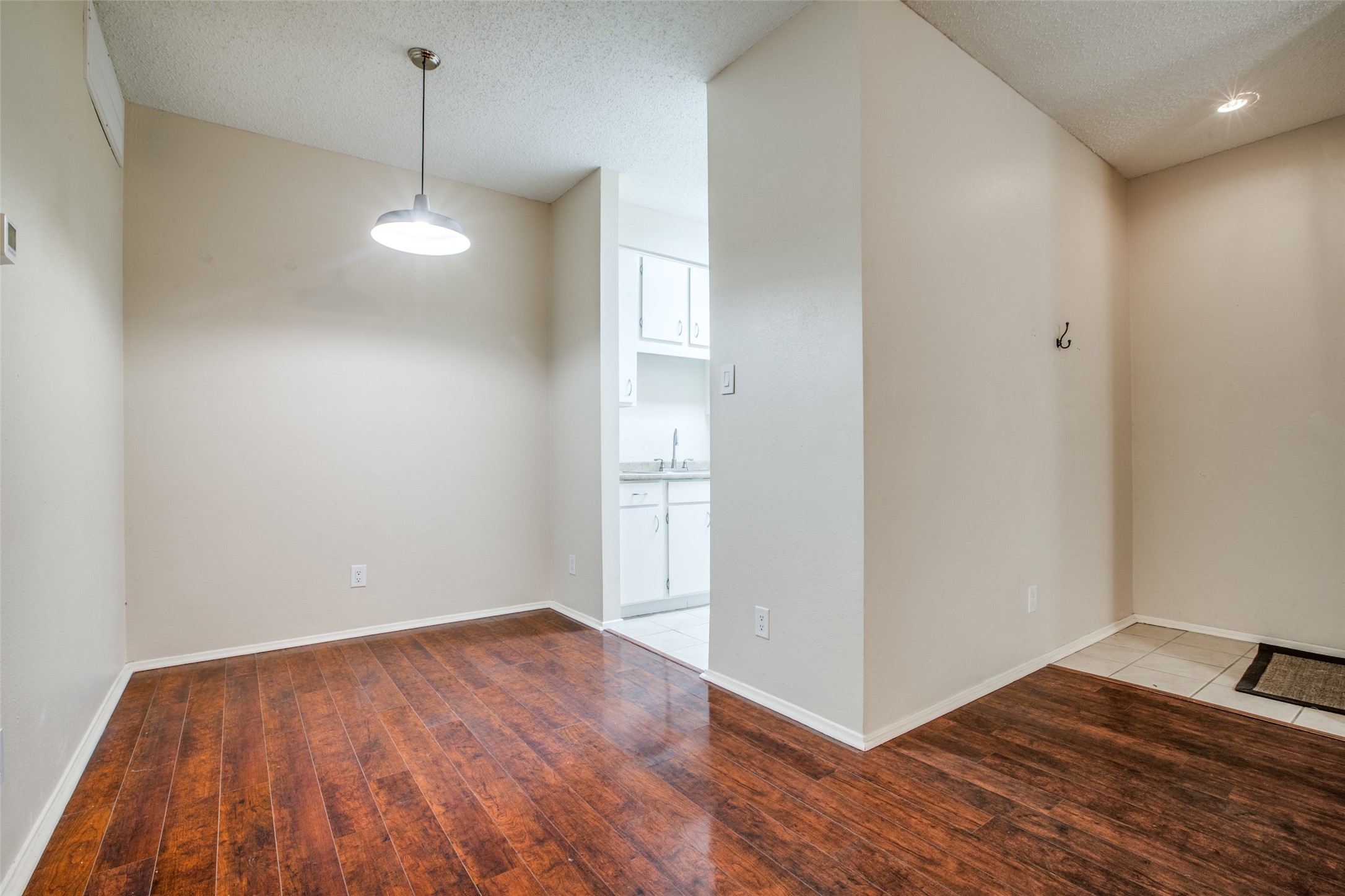 View of dining/kitchen from bedroom hallway- the condo entry (tile) on the right View of dining/kitchen from bedroom hallway- the condo entry (tile) on the right