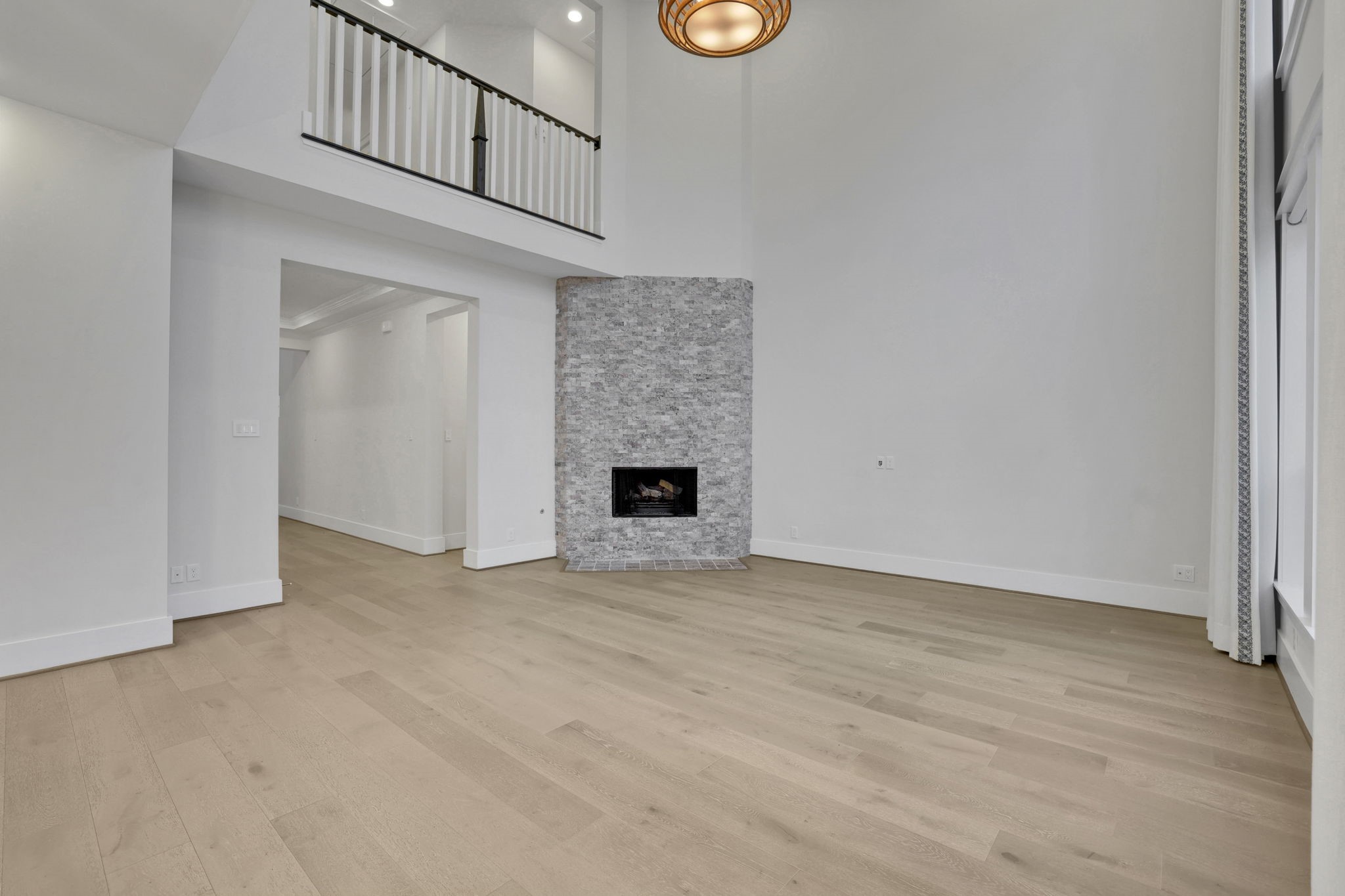 An unfurnished view shows the room's height and natural light.