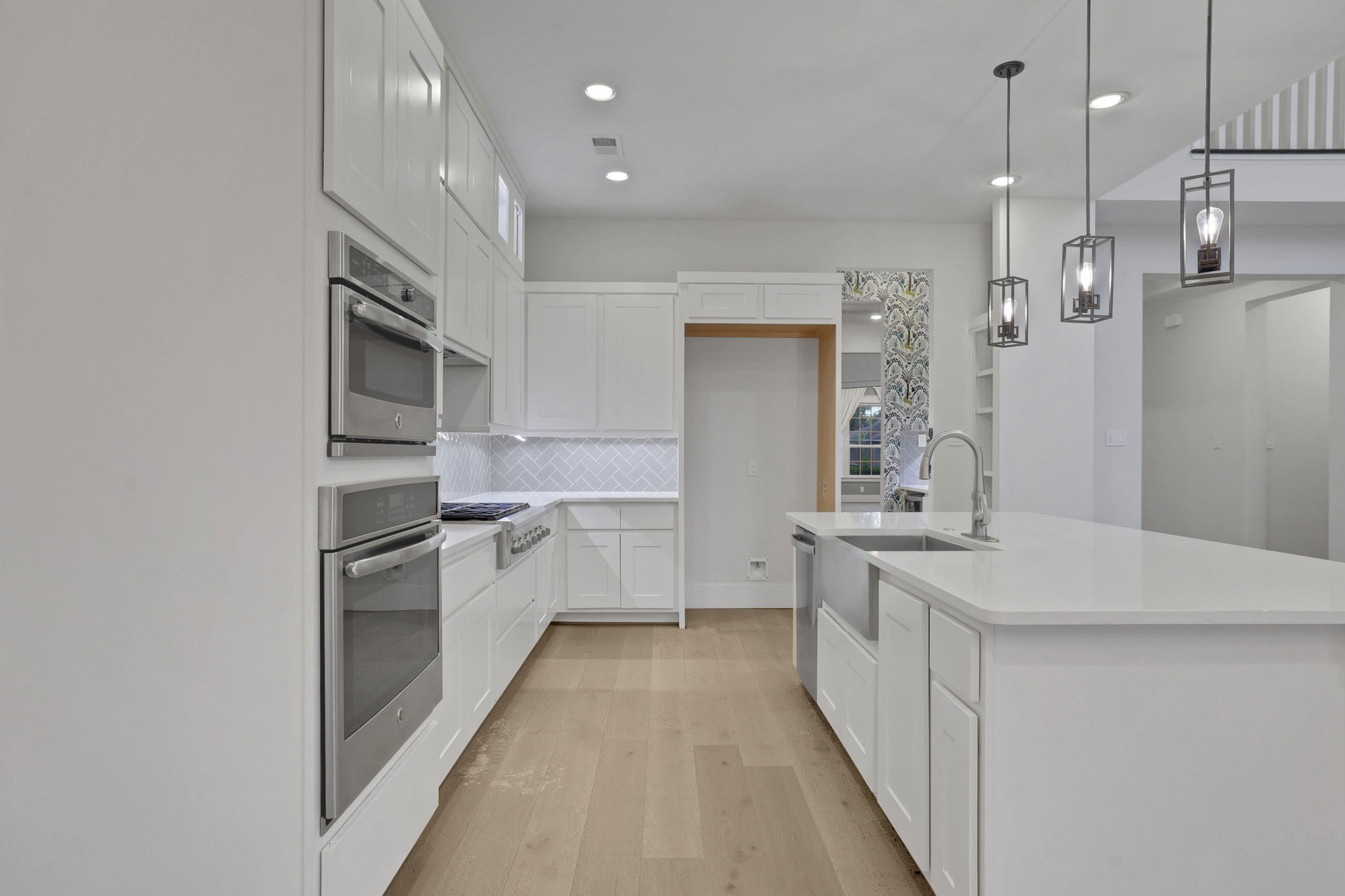 Built in ovens and white cabinetry keep the kitchen clean and functional.
