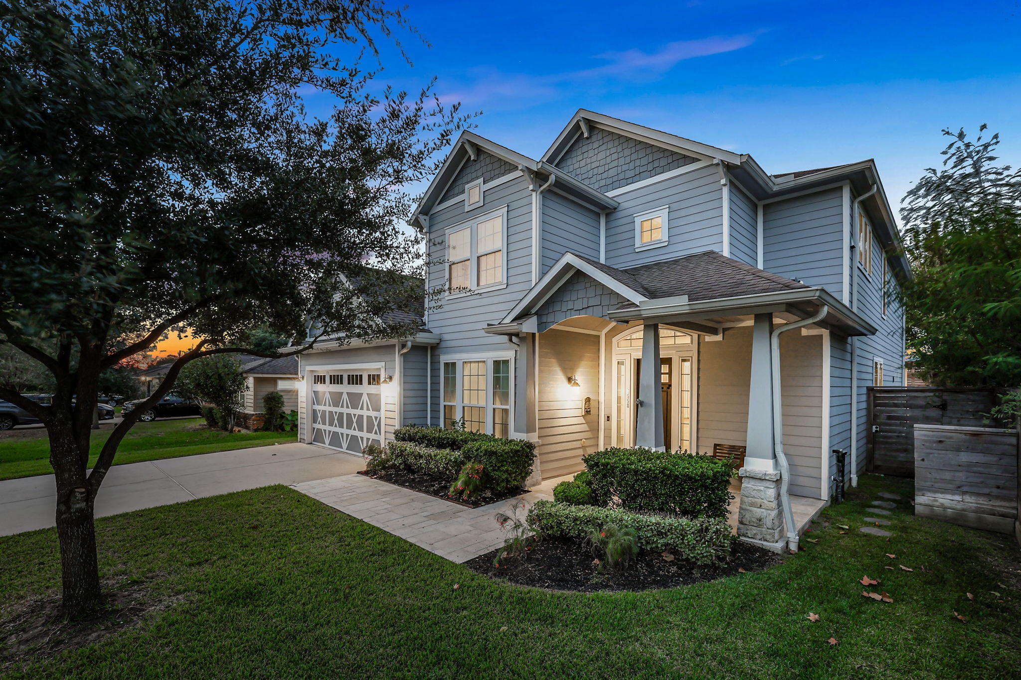 Evening light across the front elevation and mature trees.