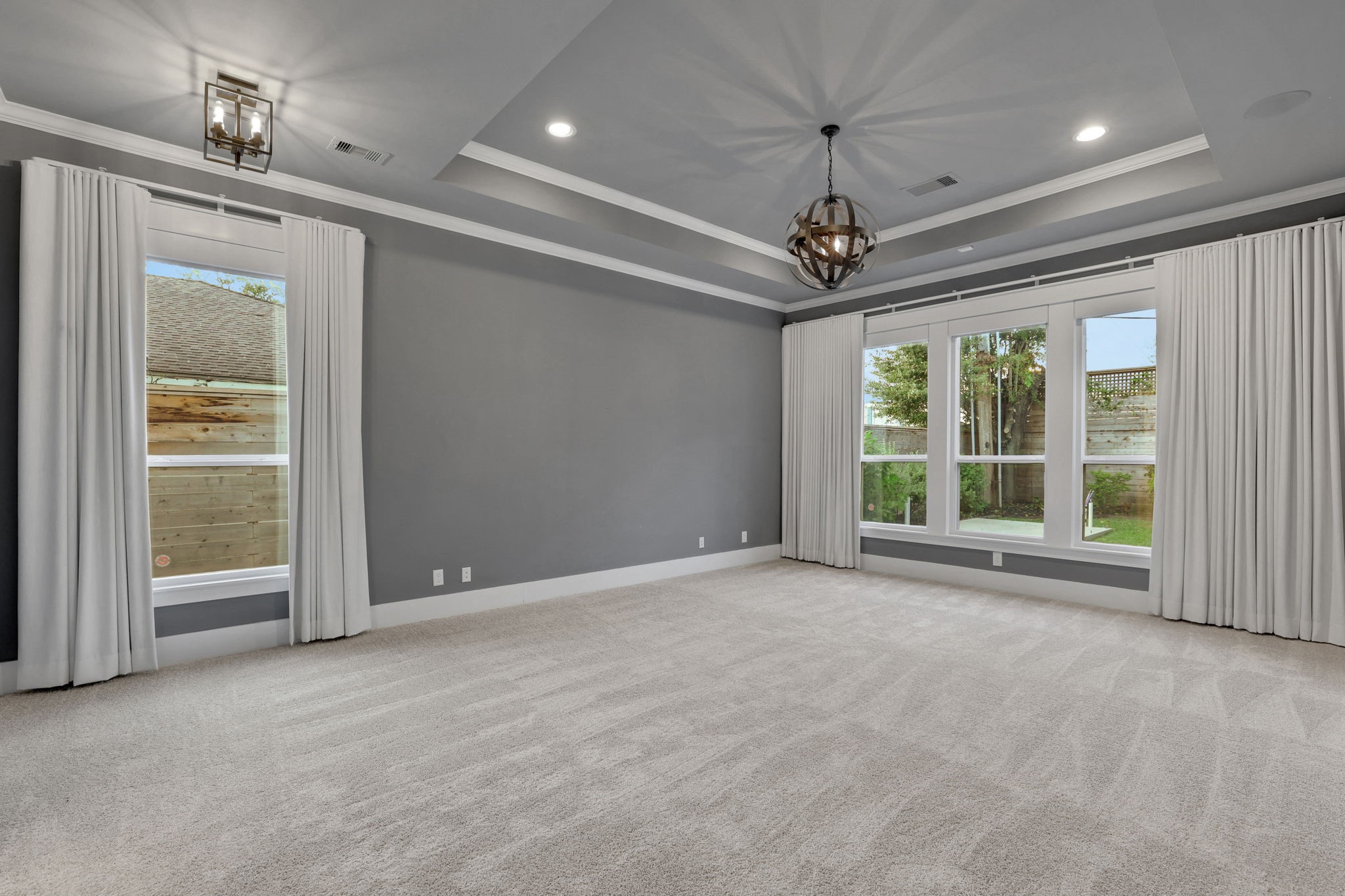 Natural light and a tray ceiling define this bedroom.