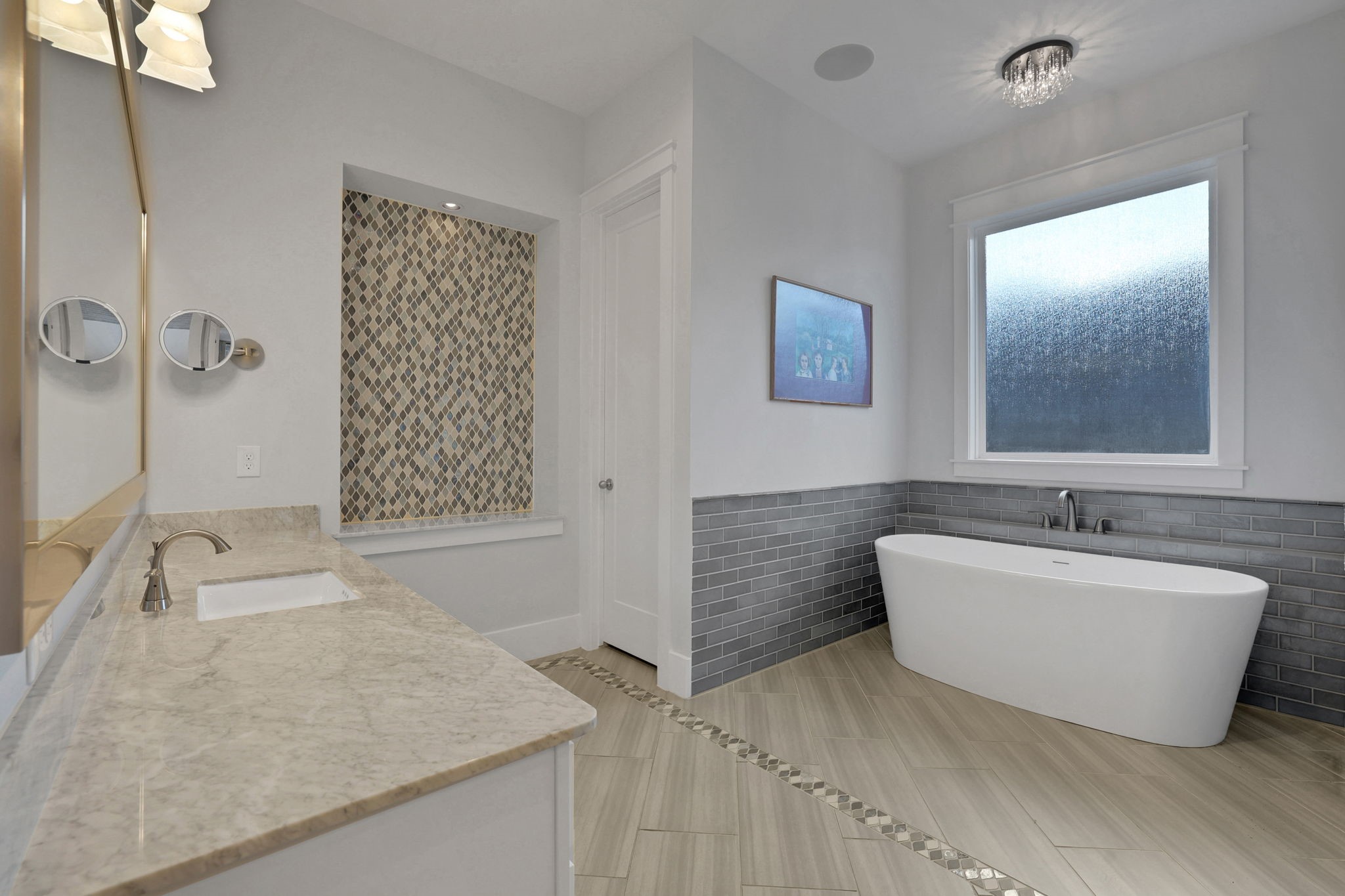 A freestanding tub sits beneath a bright window.