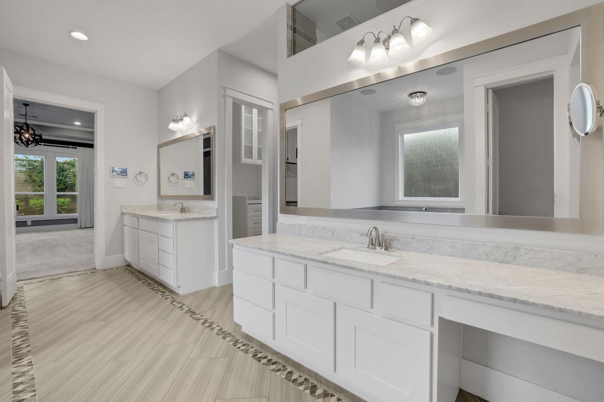 A broad vanity with layered lighting and storage below.