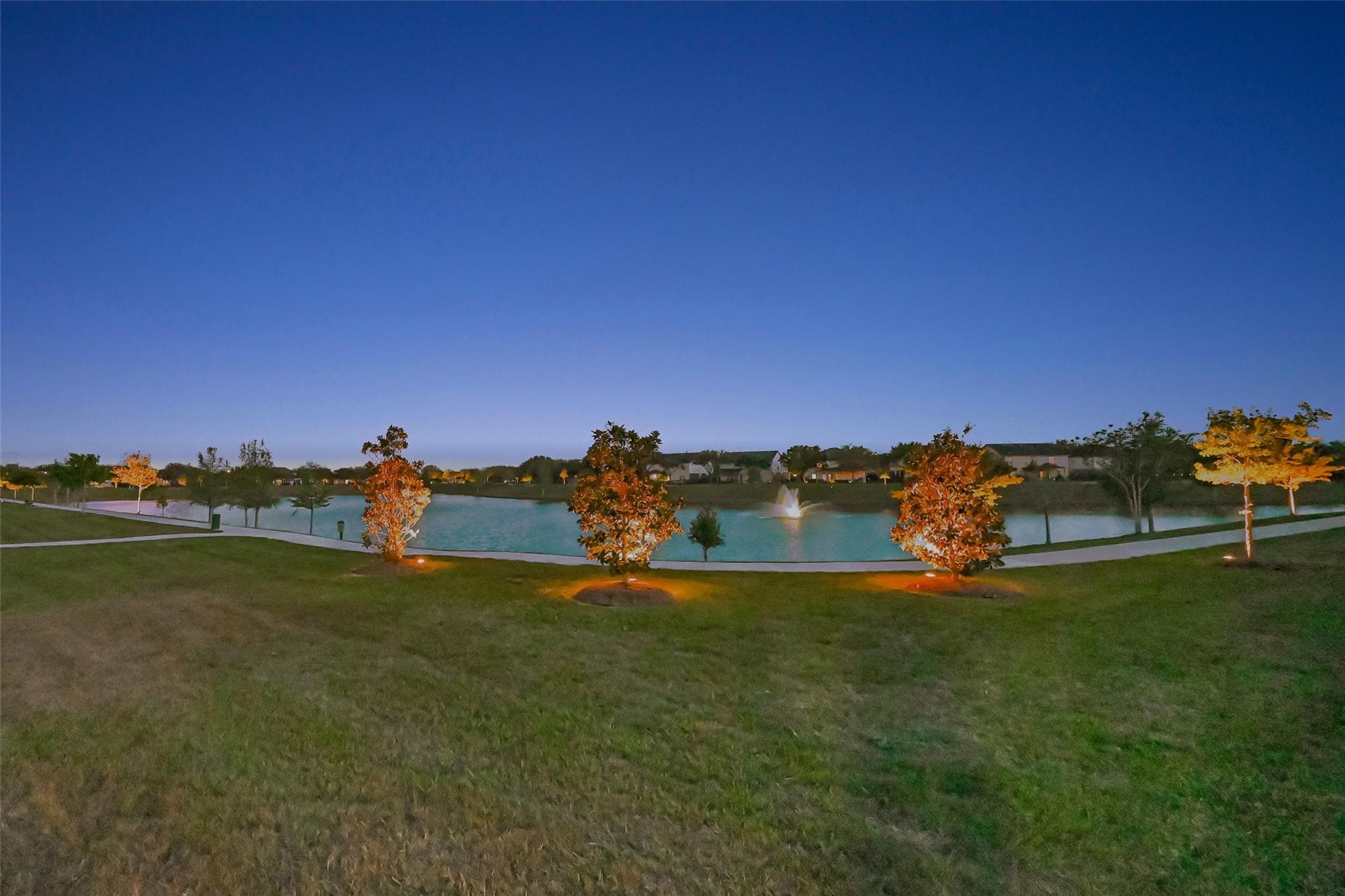 Enjoy the beautifully appointed community grounds featuring a pond, fountain, and paved walking trail highlighted by illuminated trees at dusk. The perfect location for an evening walk to wind down from a busy day, a family outing to feed the ducks and turtles, or a morning run to start the day fresh.
