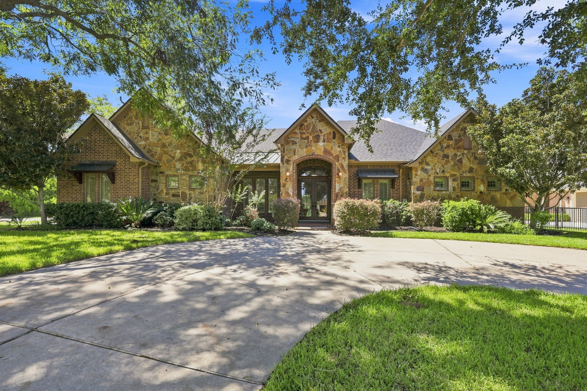 Beautifully positioned on a gorgeous wooded half-Acre lot overlooking the 2nd tee box of the golf course. A circular driveway creates an impressive arrival, while the striking exterior showcases authentic stone, tumbled brick, and a distinctive gable roof design. Mature trees surround the property, creating a peaceful, private setting and a beautiful connection to the natural landscape. Beautifully positioned on a gorgeous wooded half-Acre lot overlooking the 2nd tee box of the golf course. A circular driveway creates an impressive arrival, while the striking exterior showcases authentic stone, tumbled brick, and a distinctive gable roof design. Mature trees surround the property, creating a peaceful, private setting and a beautiful connection to the natural landscape.