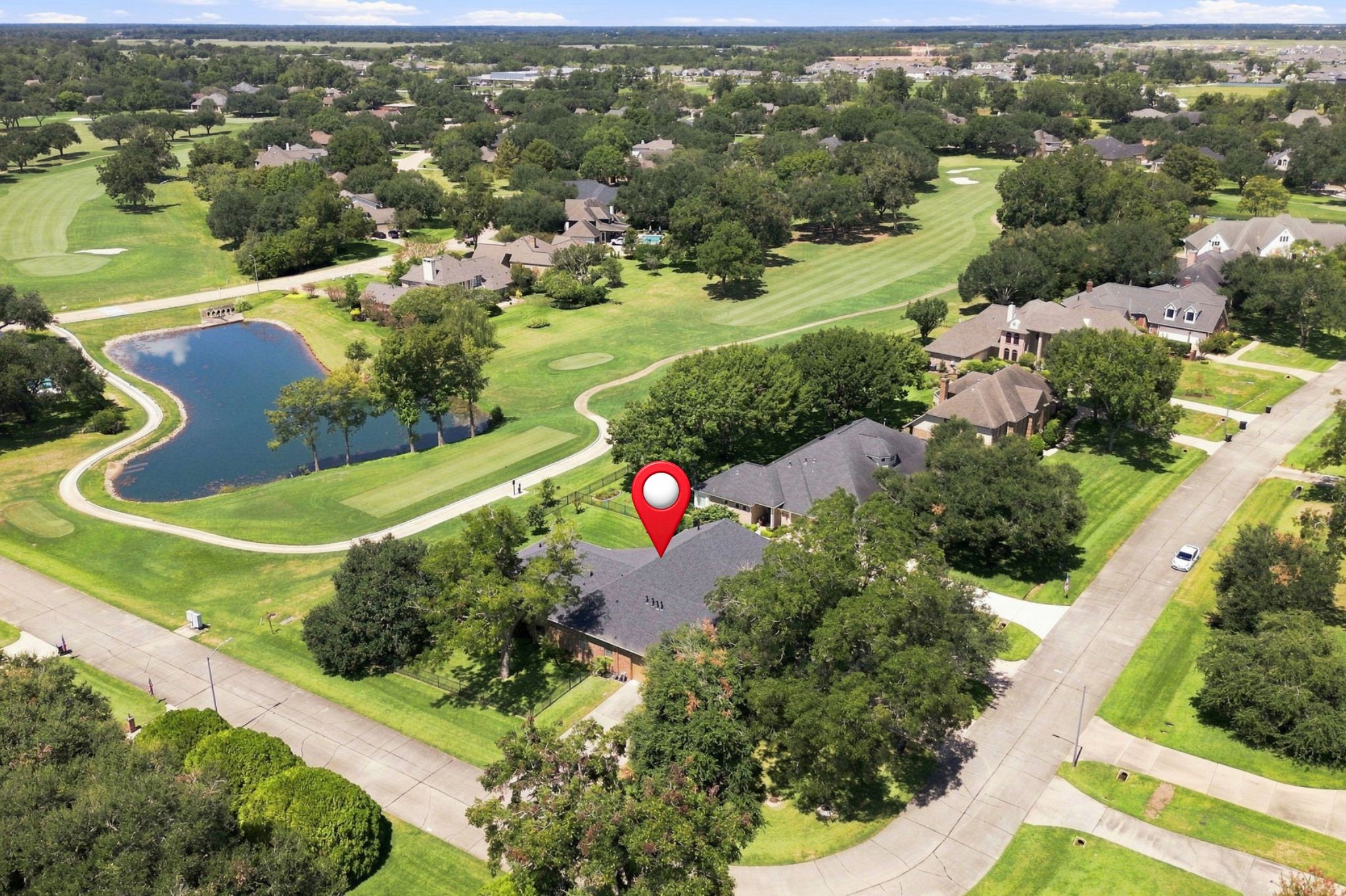This aerial view beautifully showcases the homes exceptional position on a spacious half-acre corner lot, backing to the 2nd tee box of the golf course. The expansive lot, mature trees, and picturesque golf course setting create a truly special backdrop for this remarkable property.
