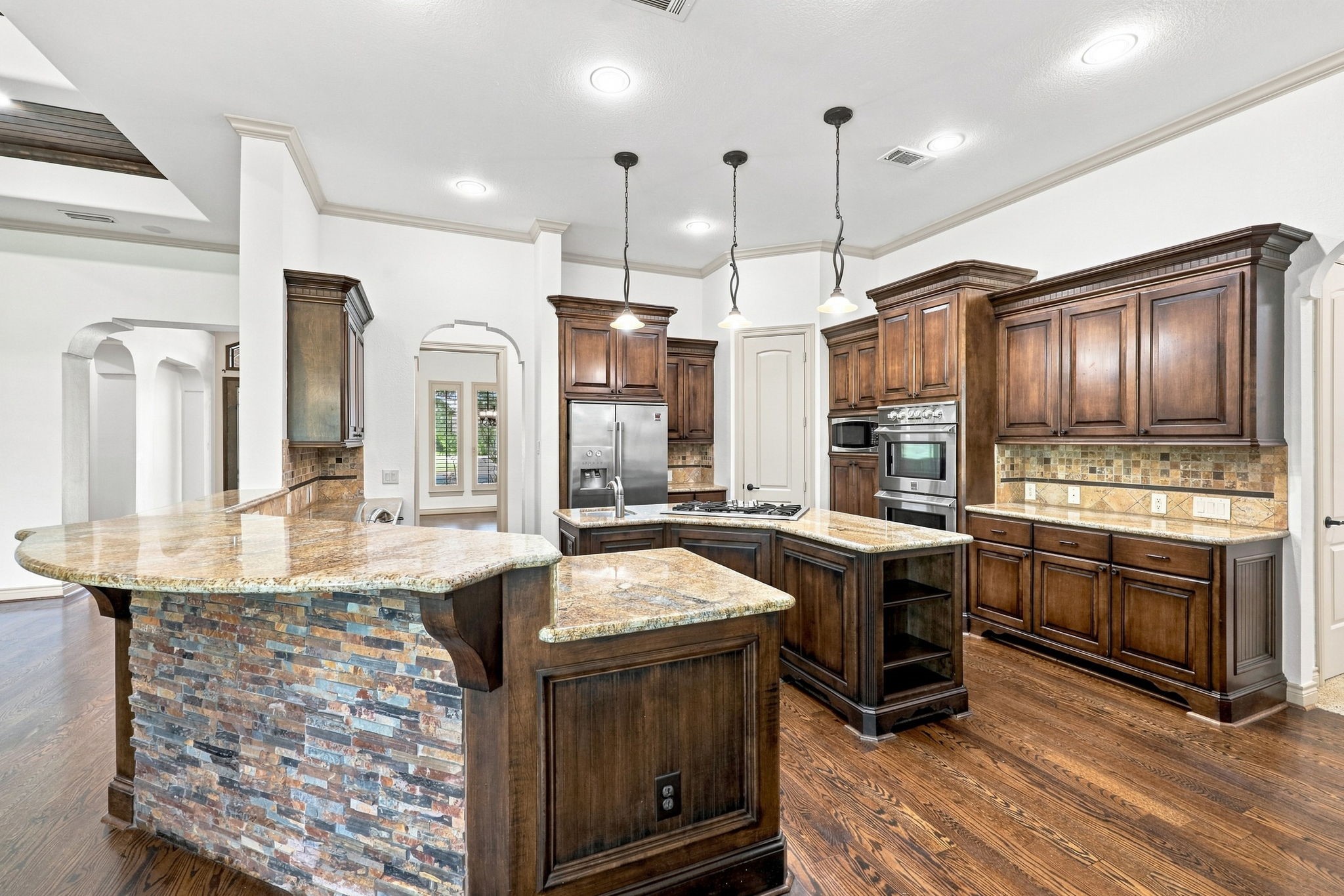 The kitchen is truly a chefs dream, featuring custom cabinetry, abundant preparation space, and gorgeous granite countertops. Stainless steel appliances complement the beautifully appointed design, while the generous workspace provides plenty of room for cooking, entertaining, and gathering with family and friends.