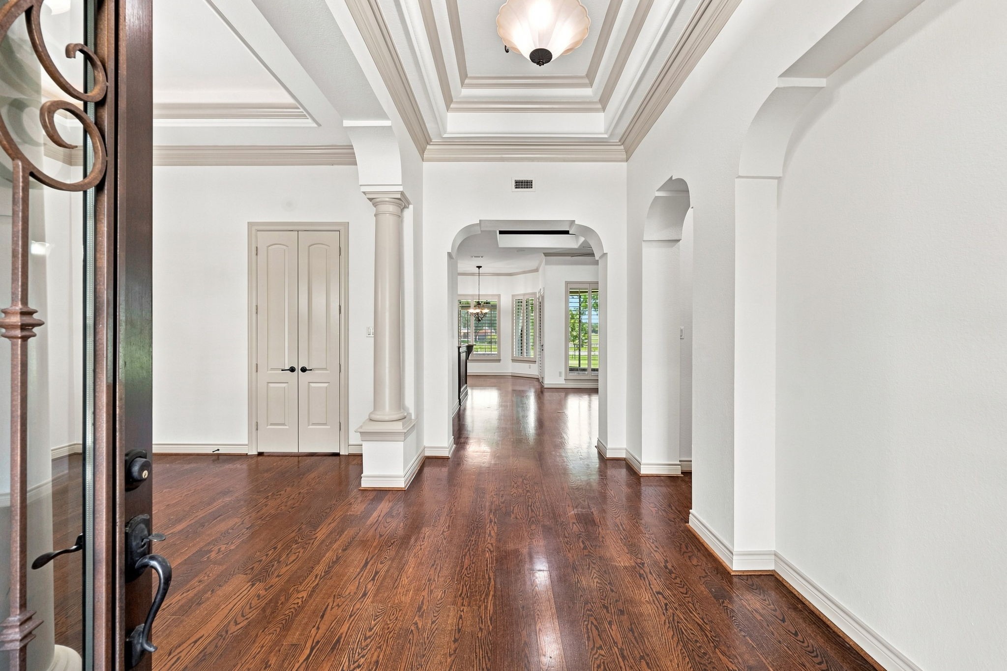 As you enter through the impressive double iron doors, you are greeted by gorgeous wood floors, freshly painted light-toned interiors, and an elegant foyer designed to make a lasting impression. A dramatic raised ceiling with detailed crown molding adds architectural character and creates a grand sense of arrival. As you enter through the impressive double iron doors, you are greeted by gorgeous wood floors, freshly painted light-toned interiors, and an elegant foyer designed to make a lasting impression. A dramatic raised ceiling with detailed crown molding adds architectural character and creates a grand sense of arrival.