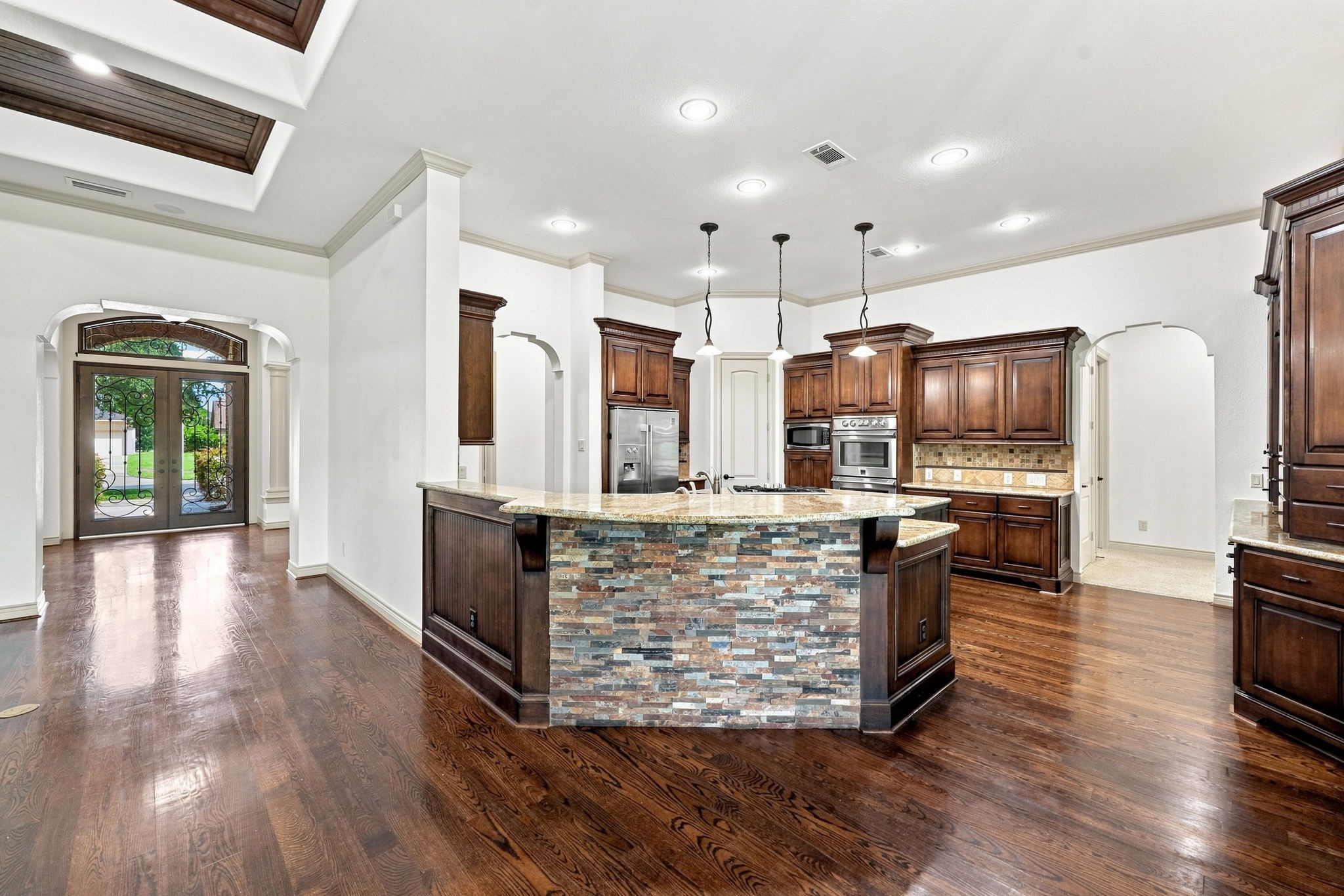 This view from the Family Room looks toward the impressive front Foyer and beautifully appointed Kitchen.