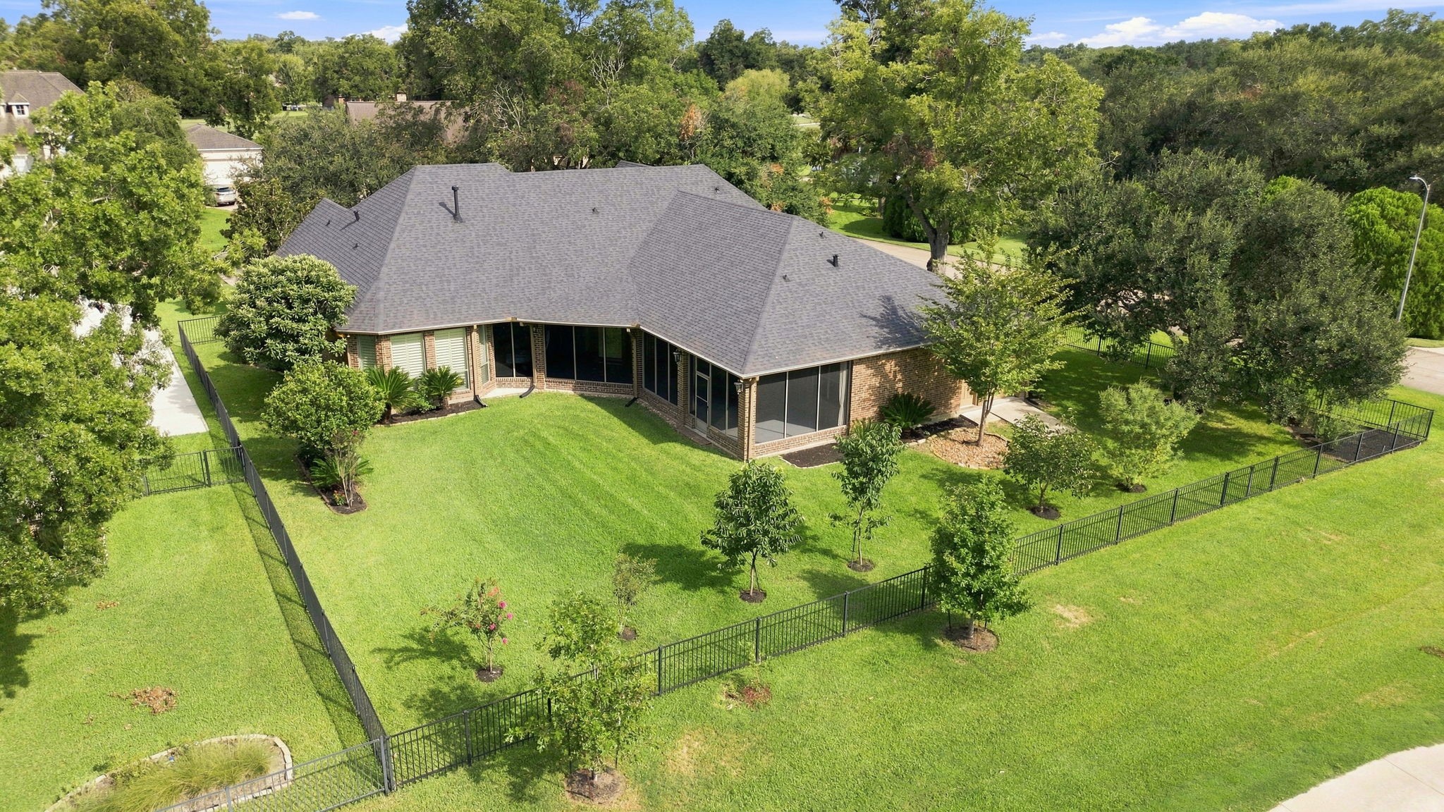 A birds-eye view beautifully showcases the generous size of the backyard, along with the elegant wrought-iron fencing that defines the property. The expansive grounds offer plenty of room for a pool, outdoor entertaining, and creating your own private backyard oasis, all while enjoying the picturesque golf course setting.