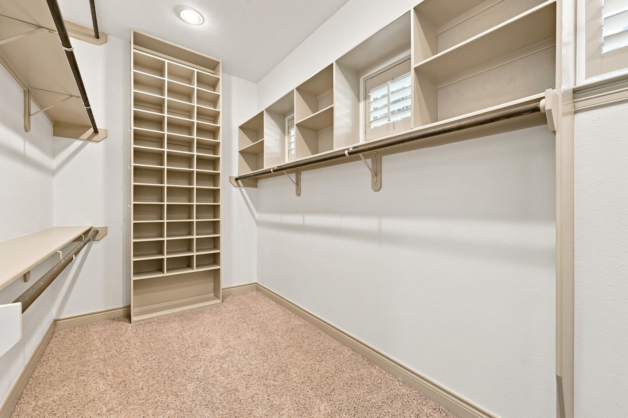 The Primary Bathroom offers two separate closets, providing exceptional storage and organization. This closet features custom built-ins designed to maximize storage while keeping clothing, shoes, and personal belongings neatly organized and easily accessible.