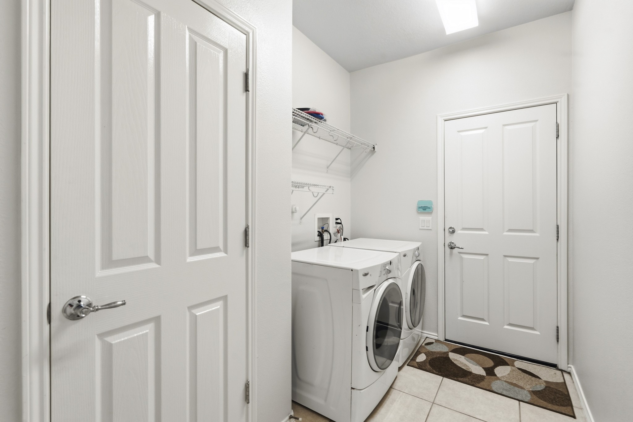 Generously sized utility room featuring included front-load washer and dryer, plus an impressive walk-in storage closet for exceptional organization.