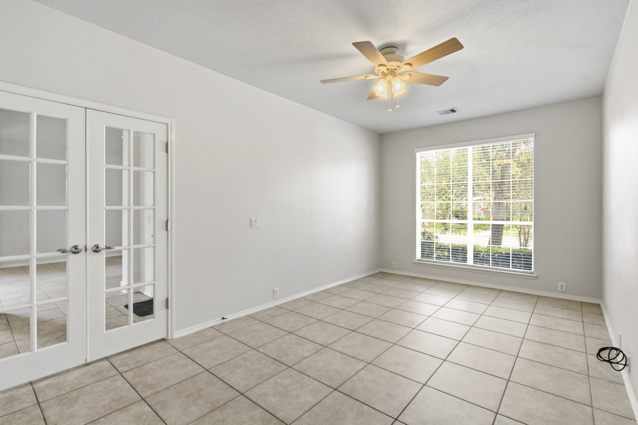 Alternate view of the study showcasing its generous size, elegant entry, and attractive views of the front lawn.