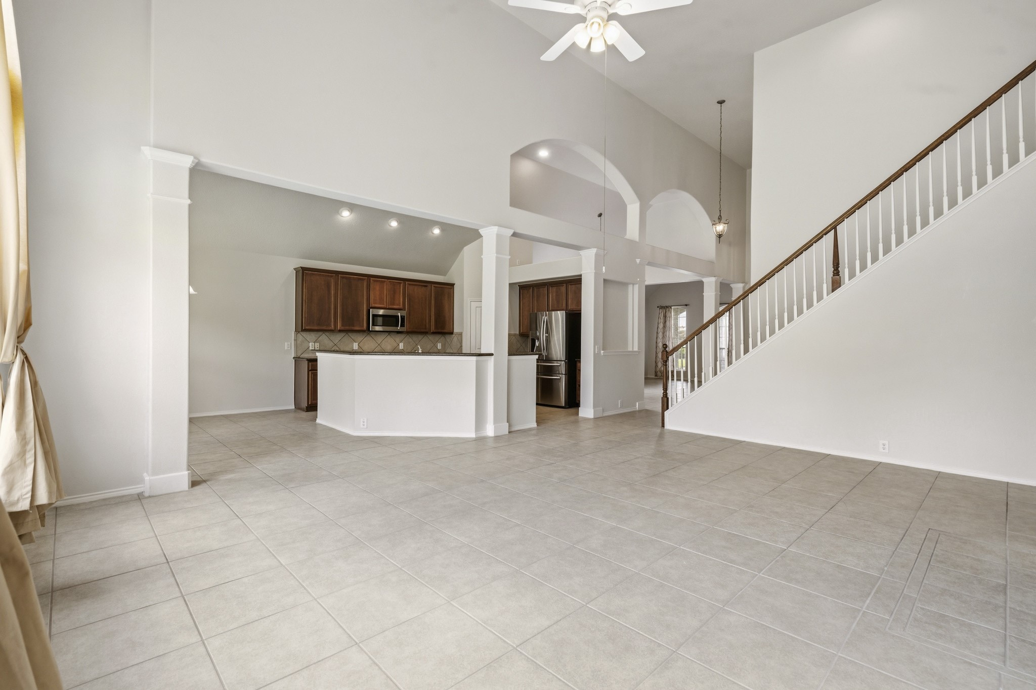 Open-concept family room flowing seamlessly into the kitchen, complete with a granite breakfast bar and beautiful architectural details throughout.