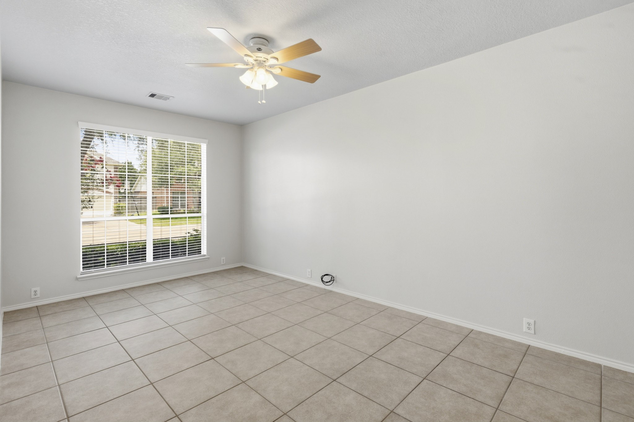 Large private study overlooking the front yard, offering a quiet and comfortable workspace filled with natural light.