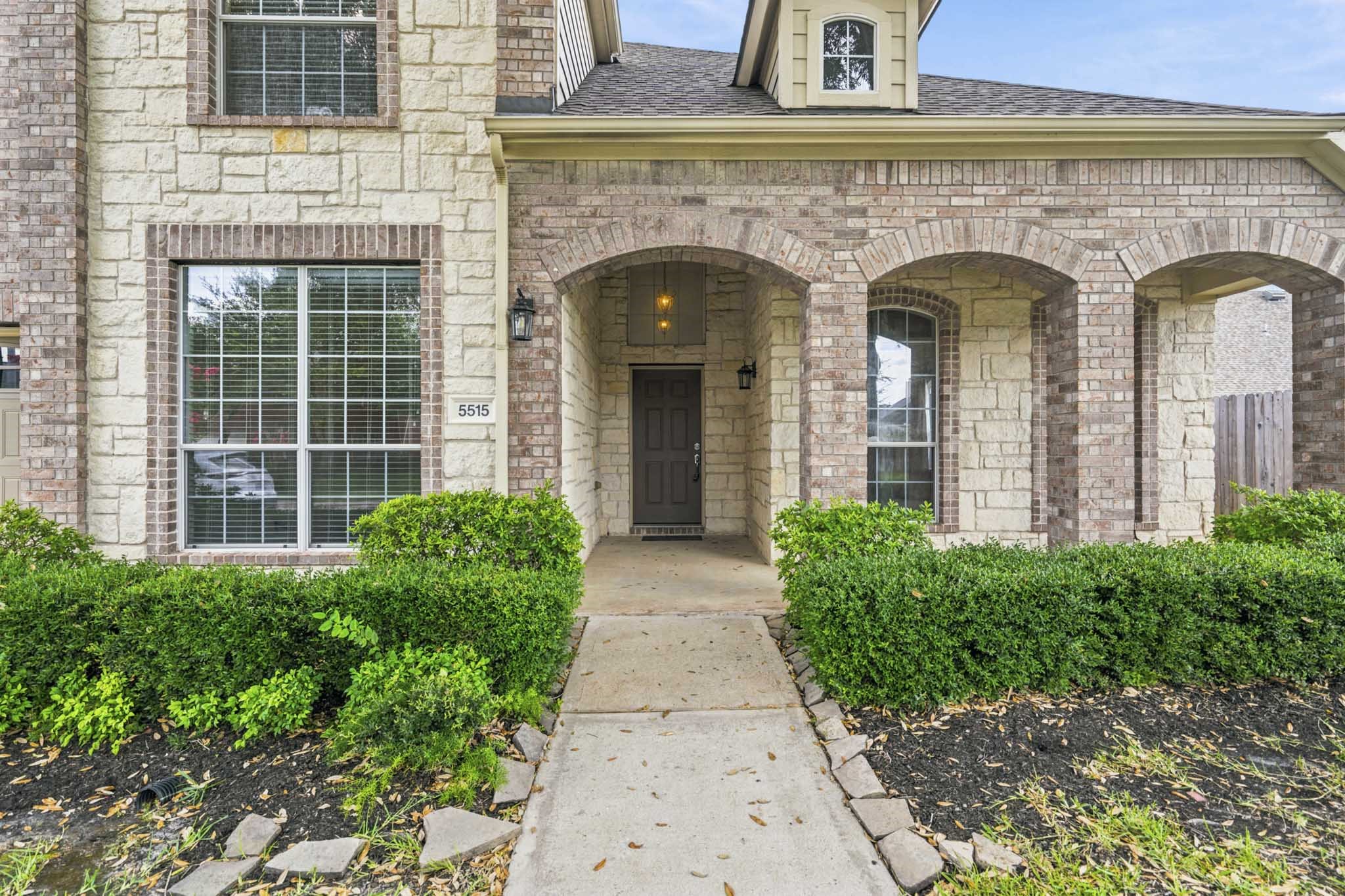 Another view of the charming covered front porch, showcasing the home's beautiful landscaping and inviting entrance.