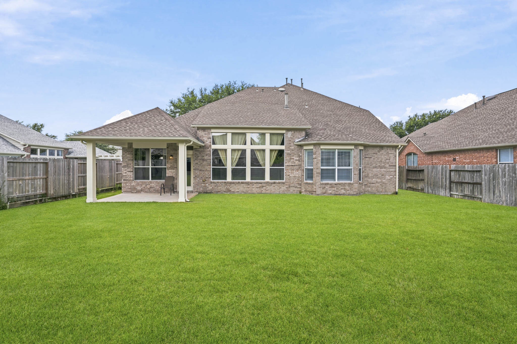 Vast pool-sized backyard featuring a covered patio, recently installed roof and gutters, and endless possibilities for outdoor living, recreation, or a future pool.