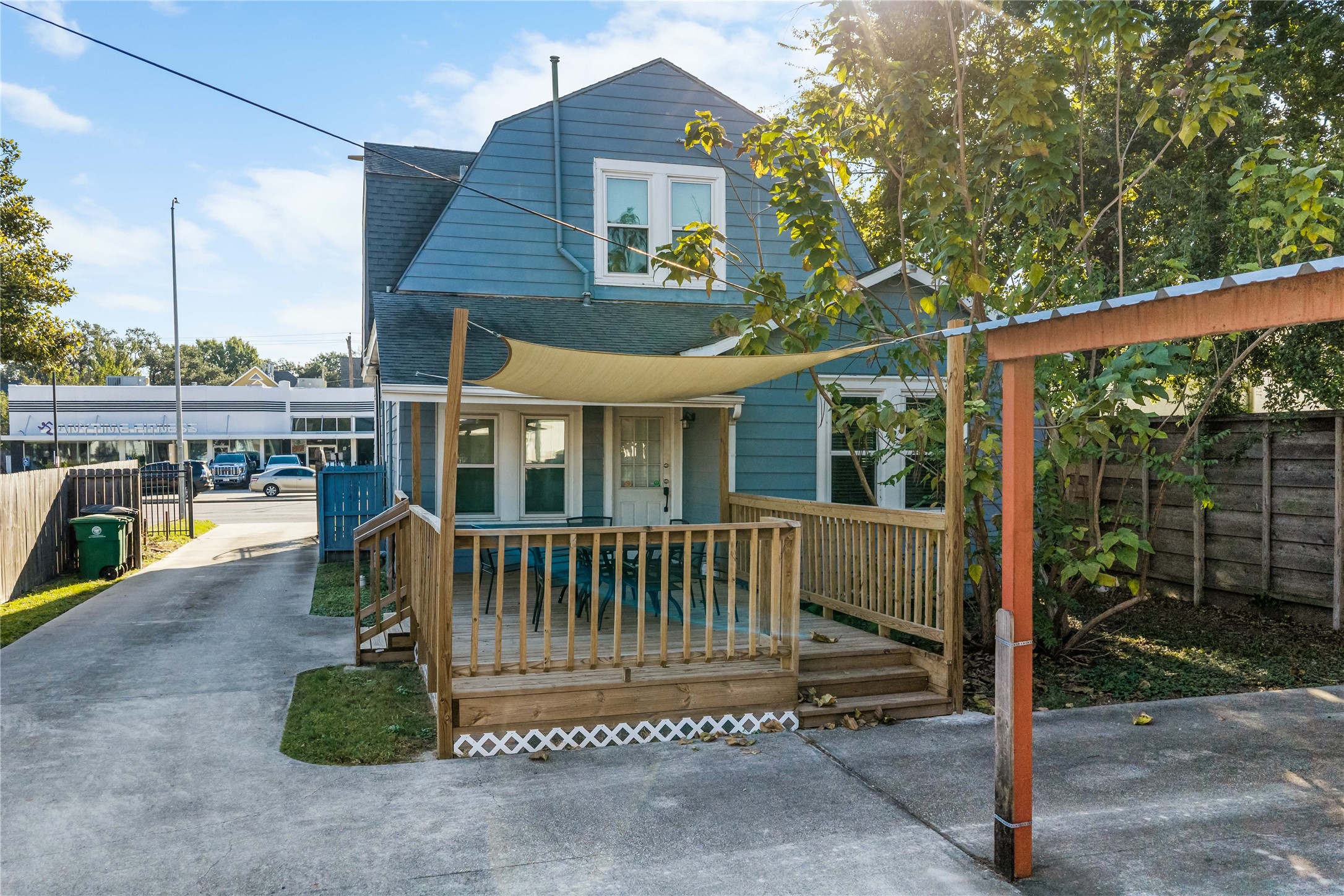 Rear exterior view showcasing the property's outdoor patio, driveway, and convenient parking arrangement.