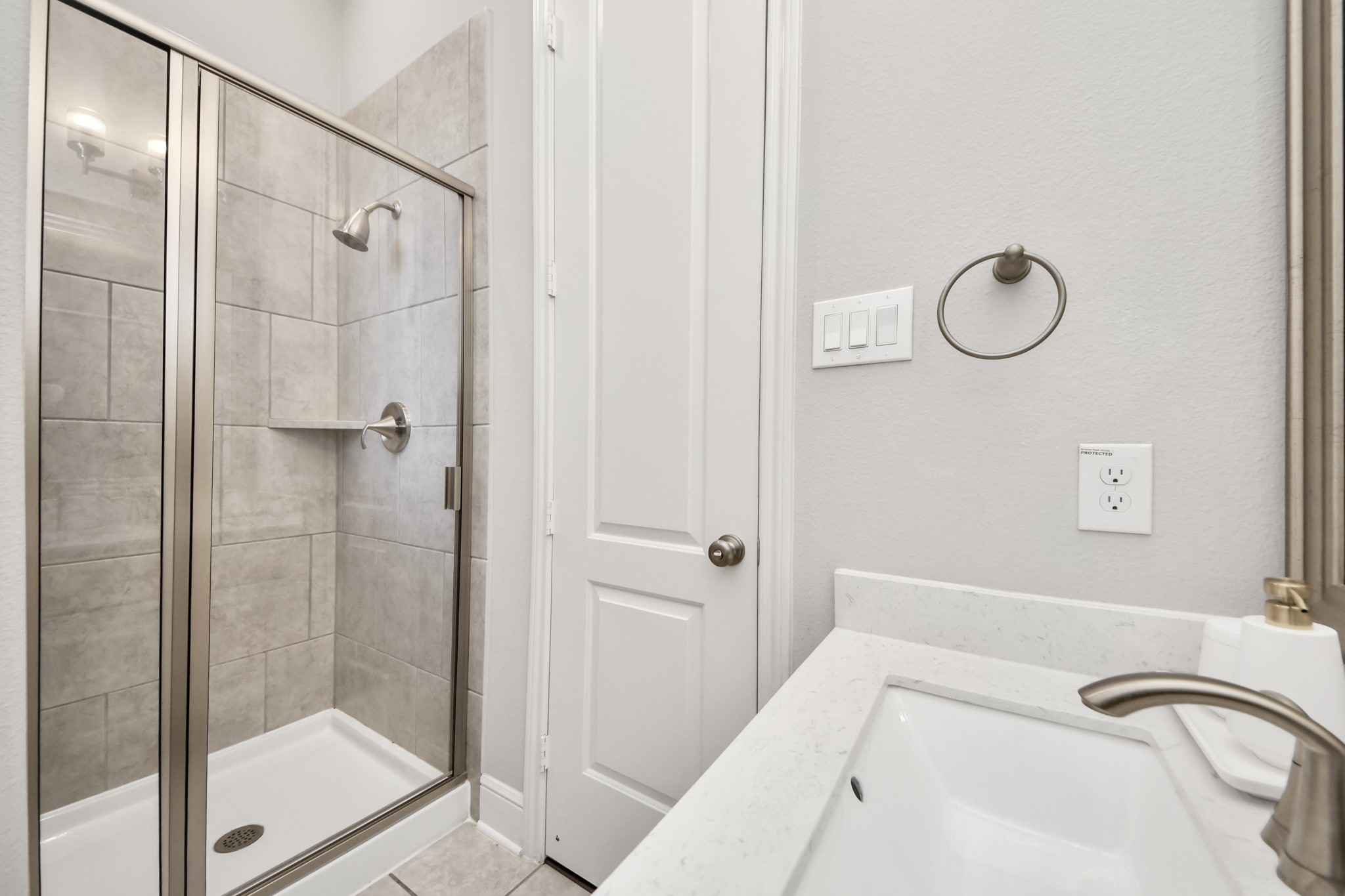 Beautifully appointed bathroom featuring a glass-enclosed shower and modern finishes.
