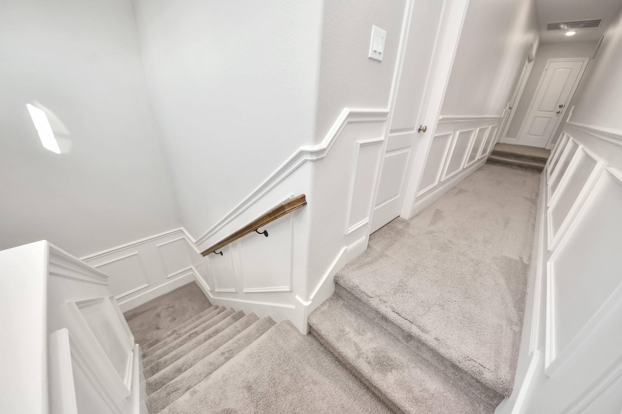 Convenient rear staircase providing easy access between the upstairs game room and media room and the main level, leading to the mudroom, garage entrance, breakfast area, and kitchen.