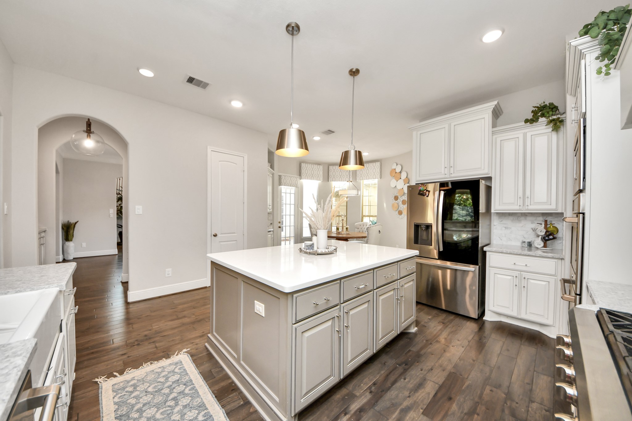 Another view of the gourmet kitchen overlooking the breakfast area, featuring a spacious center island, walk-in pantry, and convenient butler's pantry with additional cabinetry and countertop space.