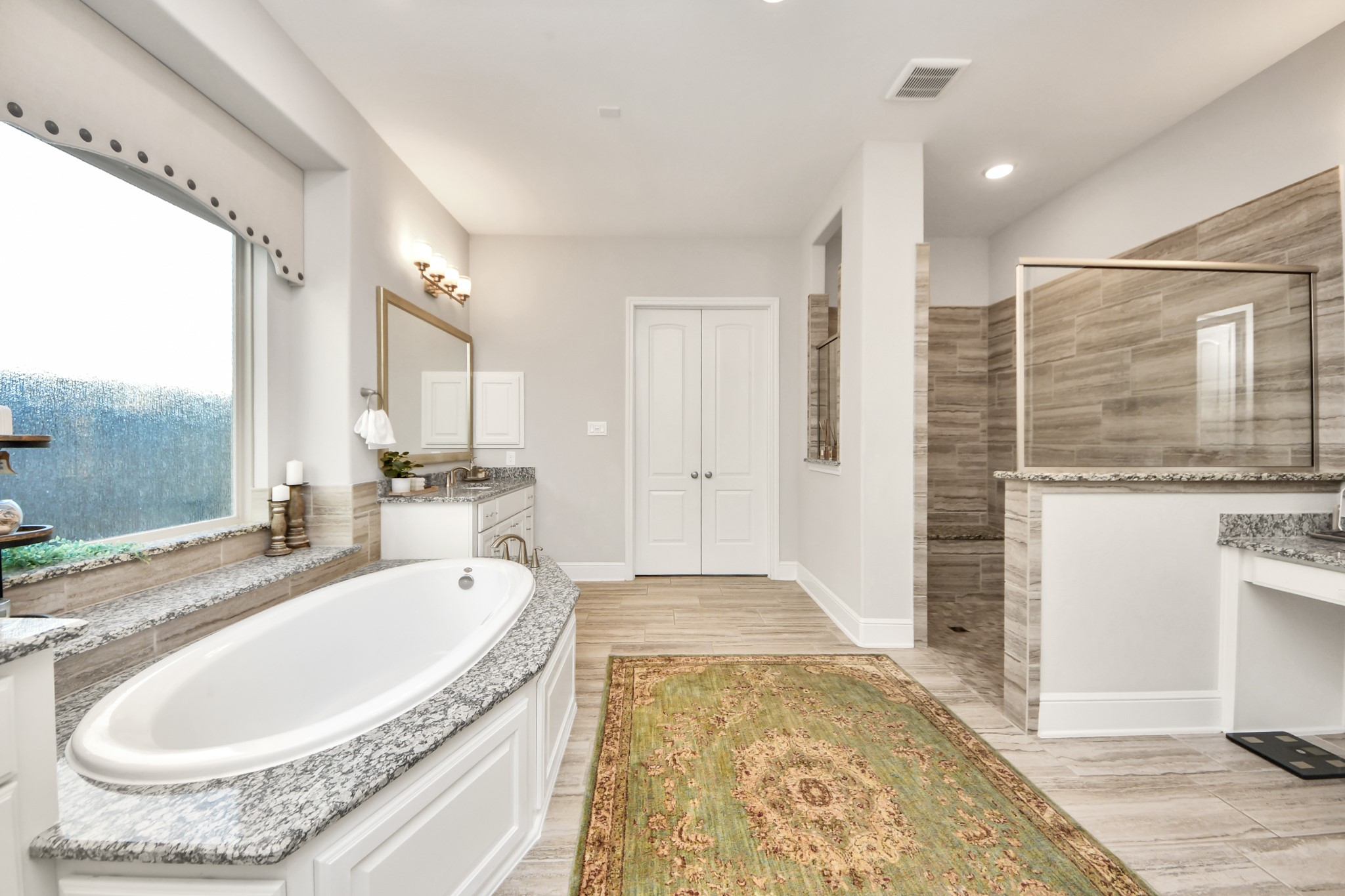 Luxurious primary bathroom featuring a spacious walk-in shower with built-in bench and a dedicated makeup vanity with an illuminated mirror.