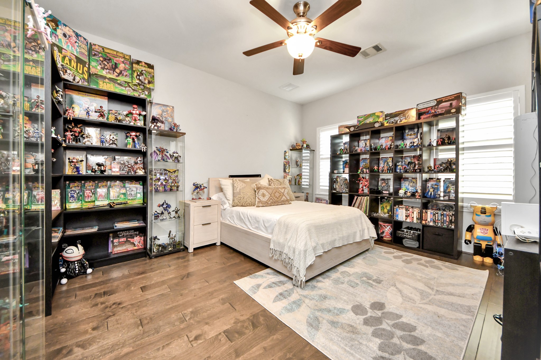 One of two spacious secondary bedrooms upstairs, featuring rich hardwood flooring, plantation shutters, and a generously sized layout.