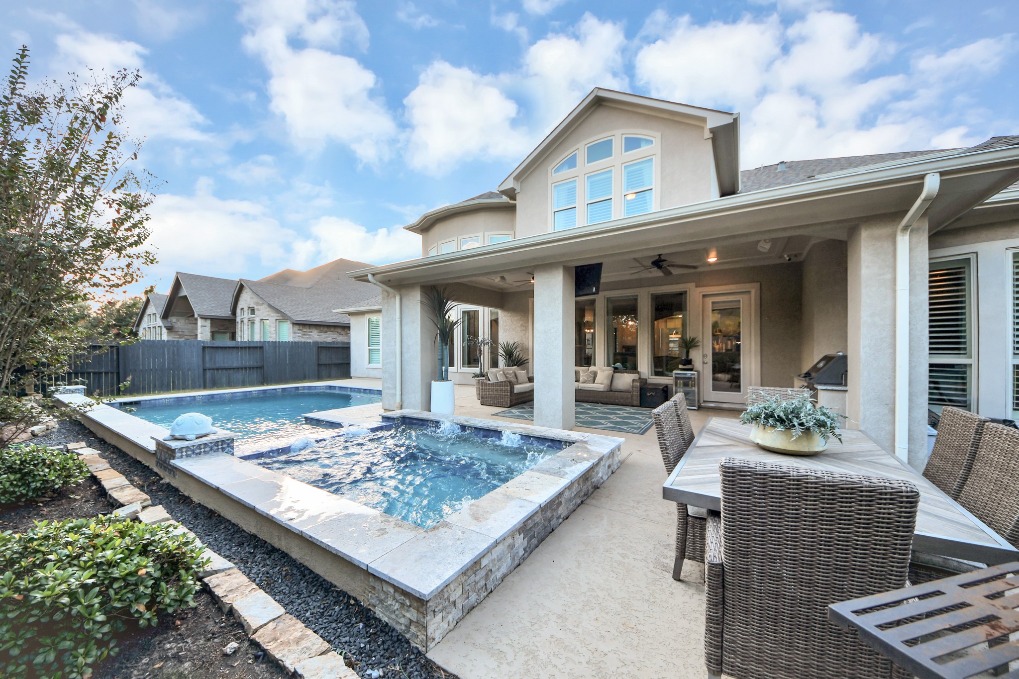 Oversized resort-style pool and spa surrounded by mature landscaping, offering exceptional privacy and a peaceful backyard retreat. An entertainer's paradise!