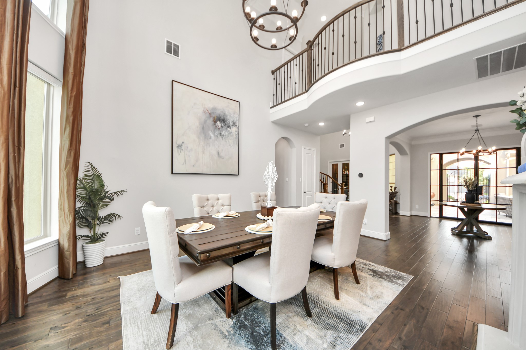 Elegant formal dining room featuring dramatic 20-foot ceilings, expansive windows, and an abundance of natural light flowing throughout the home.