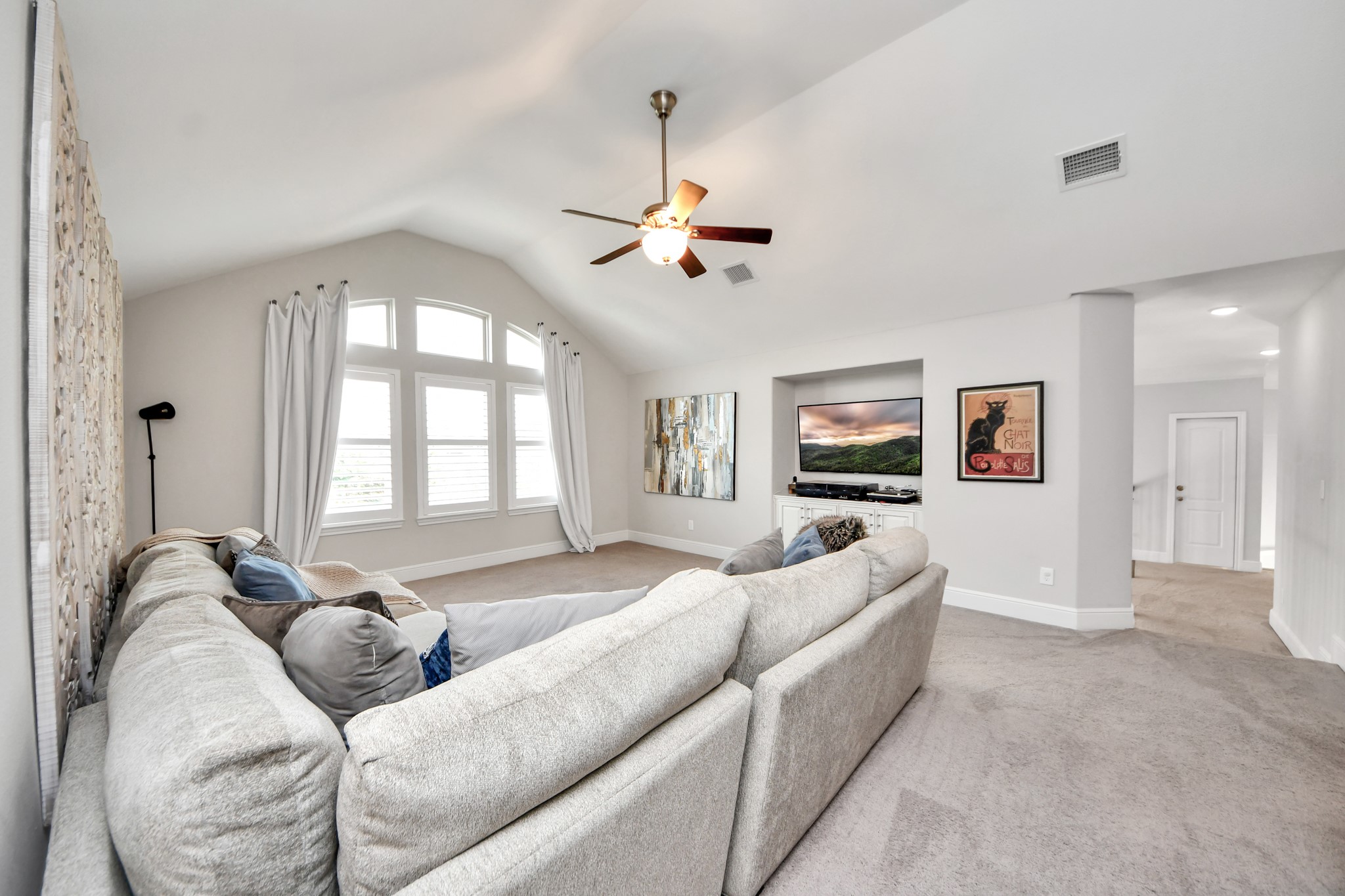 Oversized upstairs game room offering plenty of space for entertaining and relaxation, featuring plantation shutters, custom built-in cabinetry, and a spacious, versatile layout.