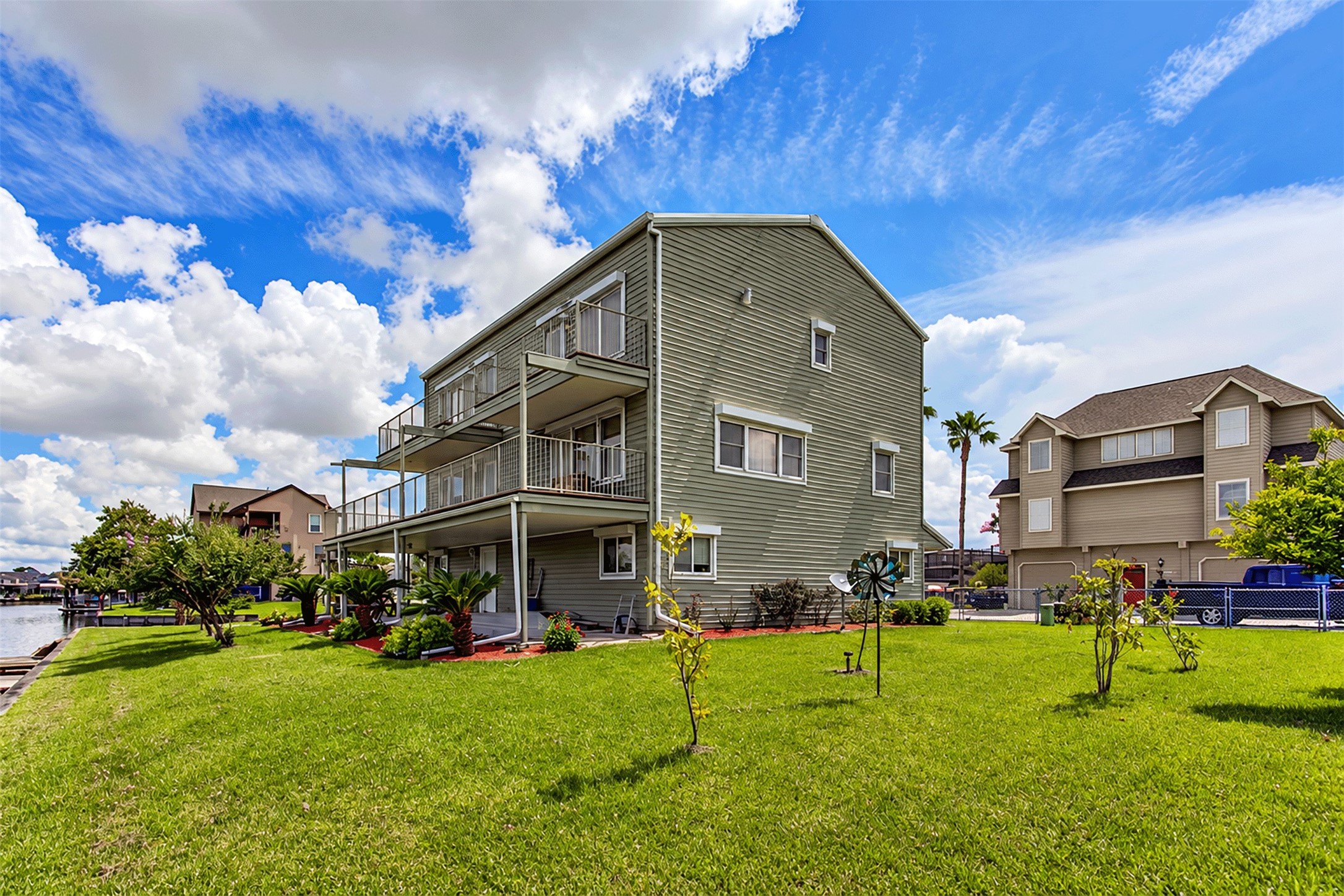Expansive green lawn and multi-level decks overlooking the canal community. Expansive green lawn and multi-level decks overlooking the canal community.