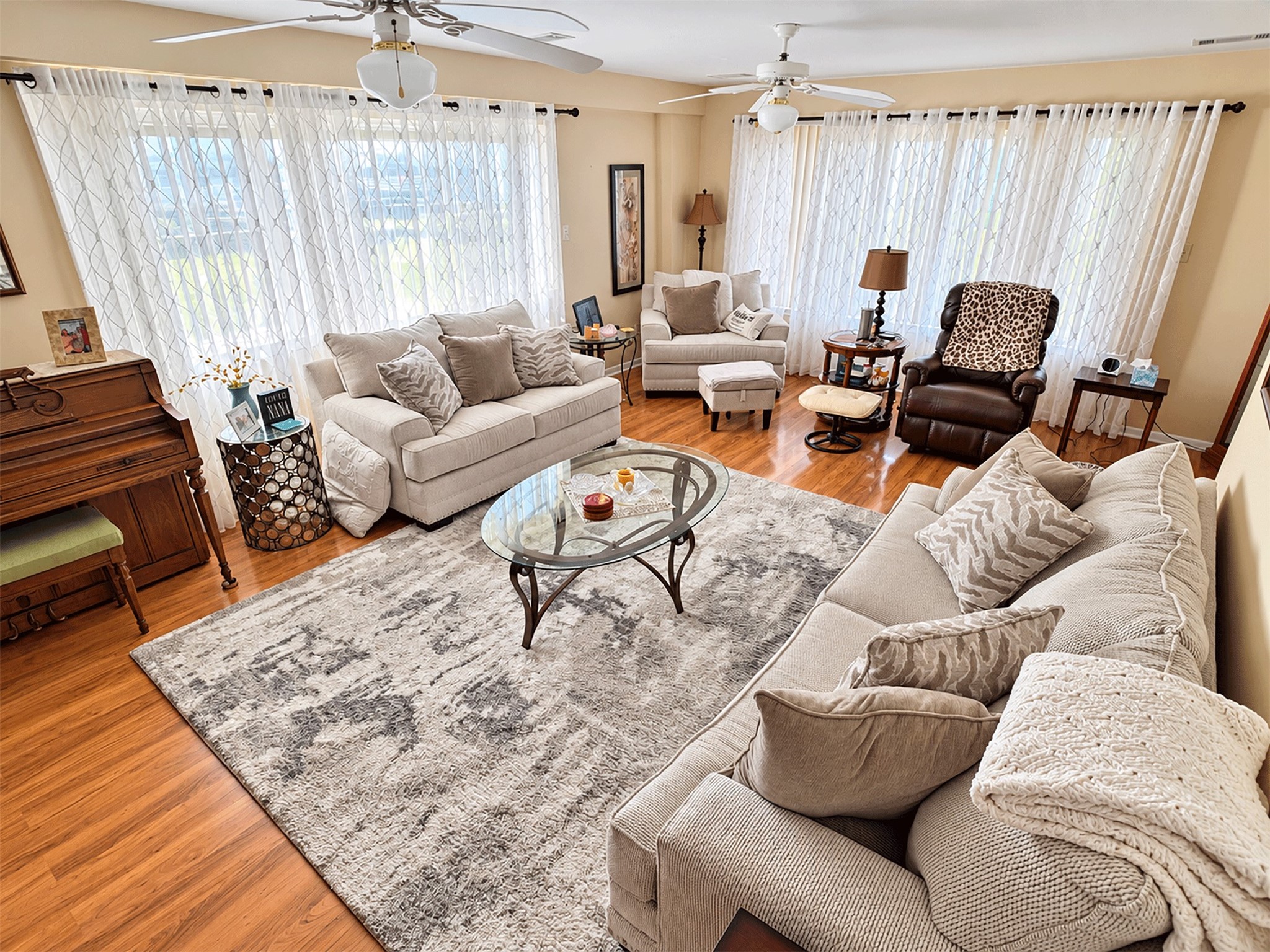 Bright first-floor living room with wood floors and abundant natural light. Bright first-floor living room with wood floors and abundant natural light.