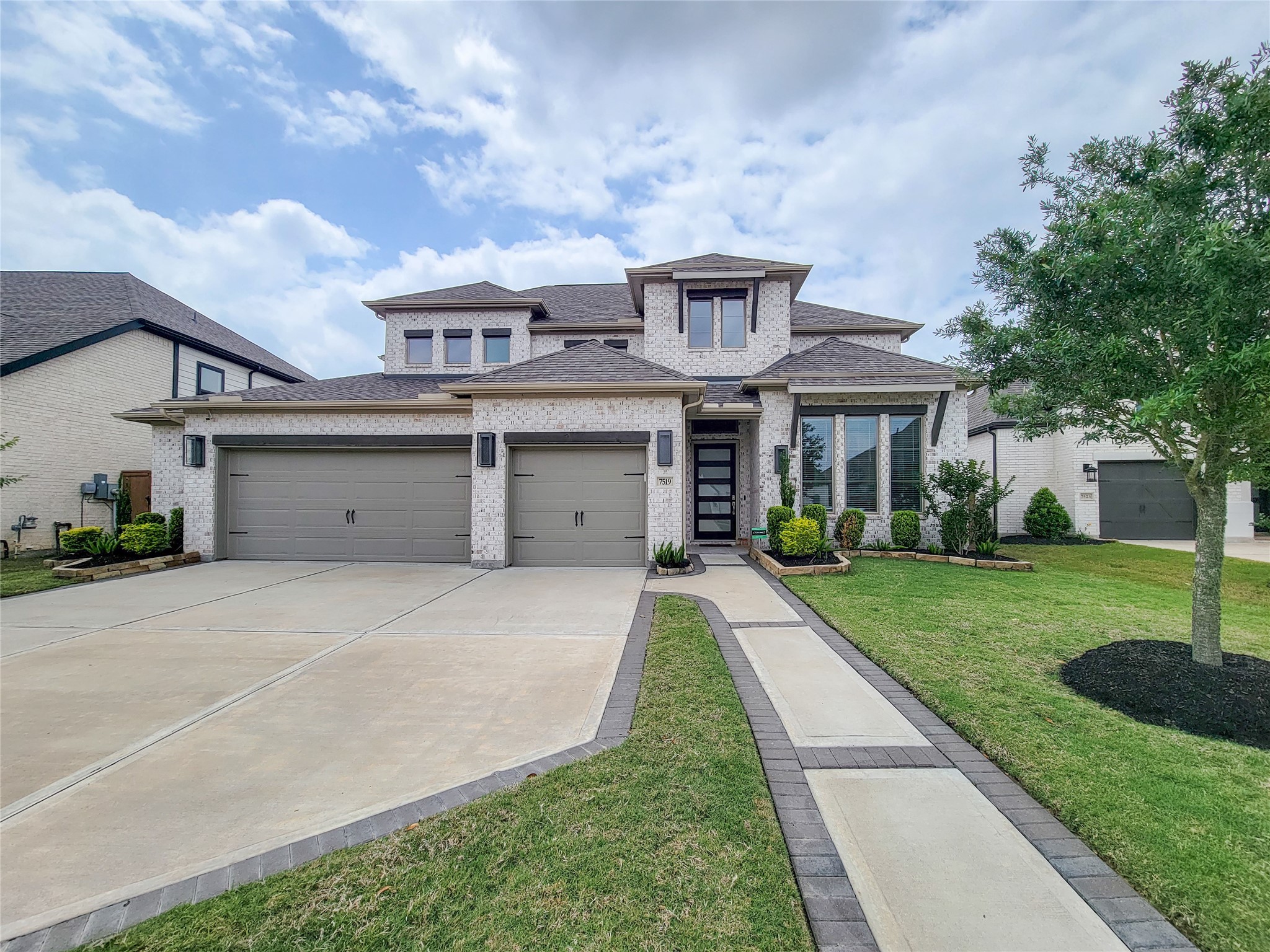 This modern two-story home features a light brick exterior, a three-car garage, and a welcoming front path. The landscaped yard includes neatly trimmed shrubs and a lush lawn, enhancing the home's curb appeal. This modern two-story home features a light brick exterior, a three-car garage, and a welcoming front path. The landscaped yard includes neatly trimmed shrubs and a lush lawn, enhancing the home's curb appeal.