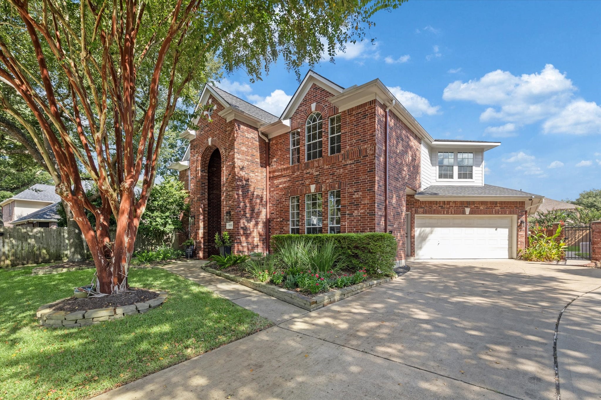 Extra wide driveway with iron gate to the yard.