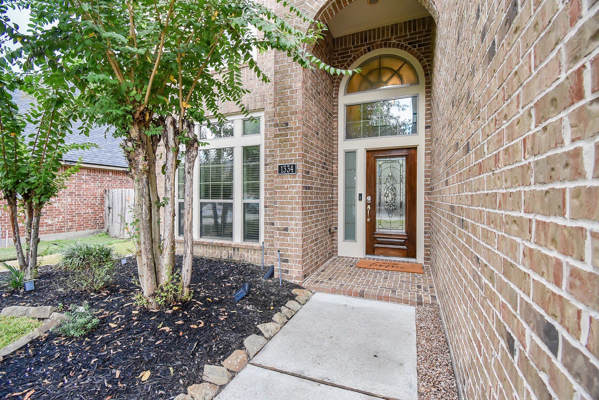 Impressive entry features solid wood door with glass insert.