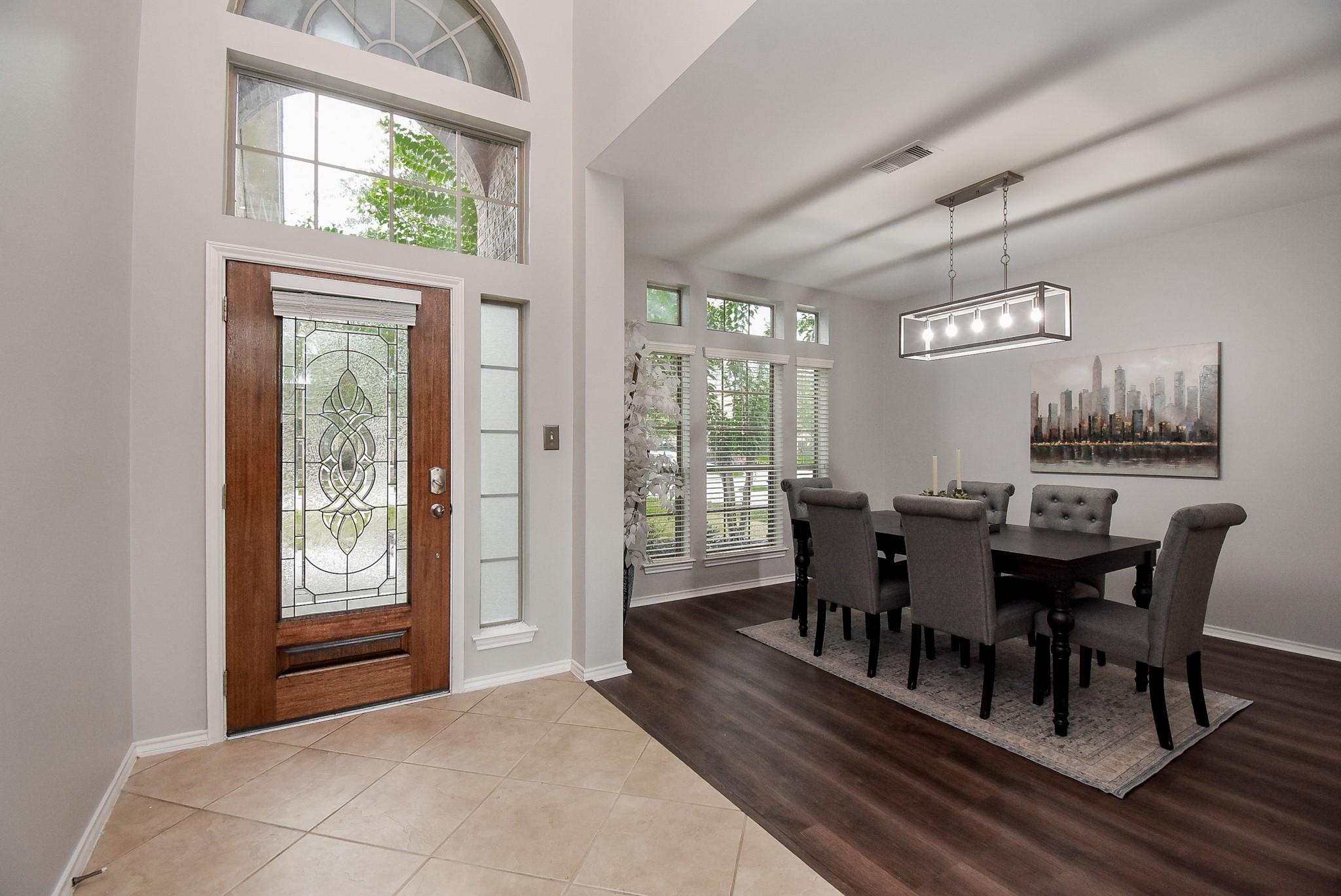 Welcoming entrance with neutral tile floors and high ceiling!