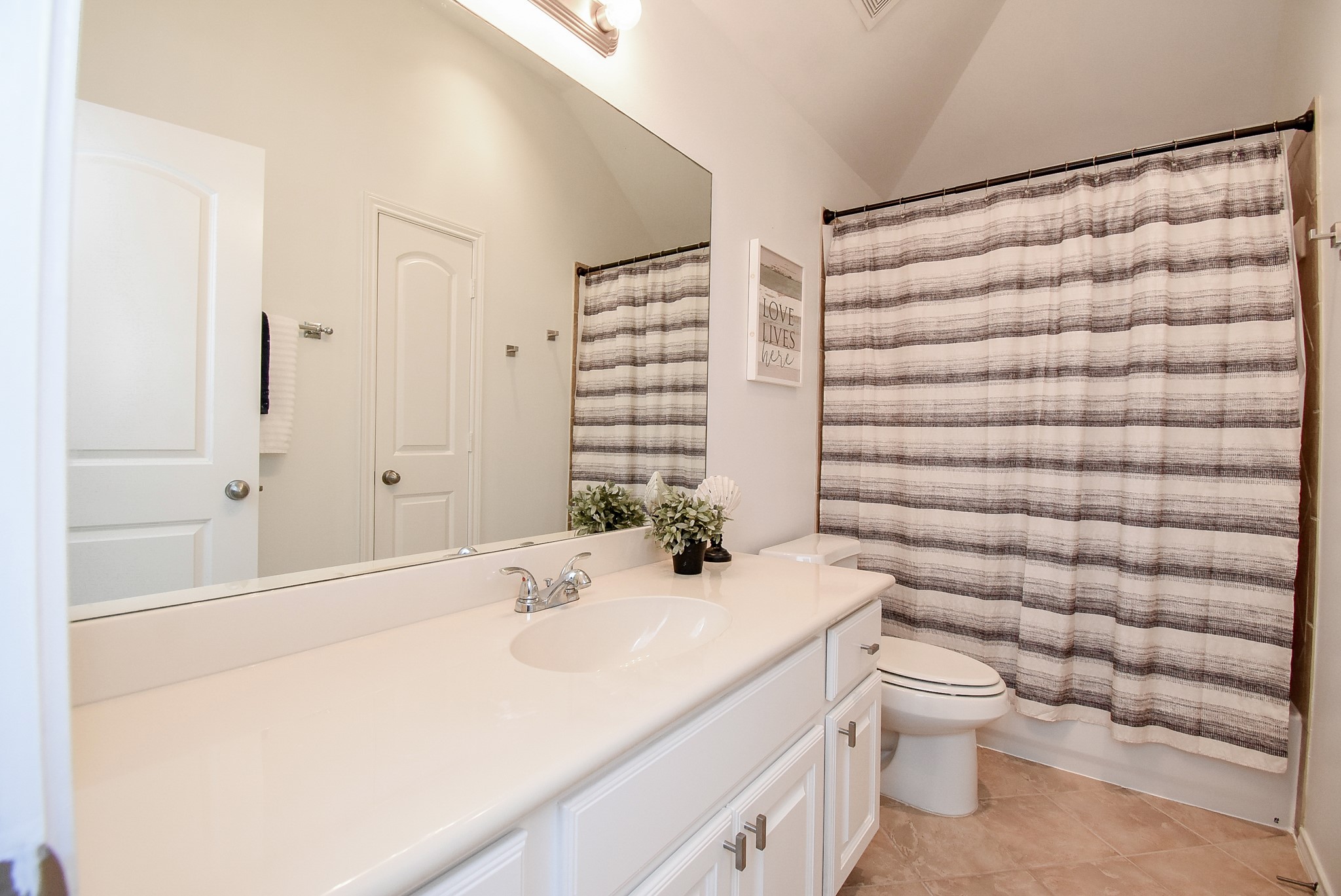Bathroom 3 has extra vanity counter space and tile shower surround.