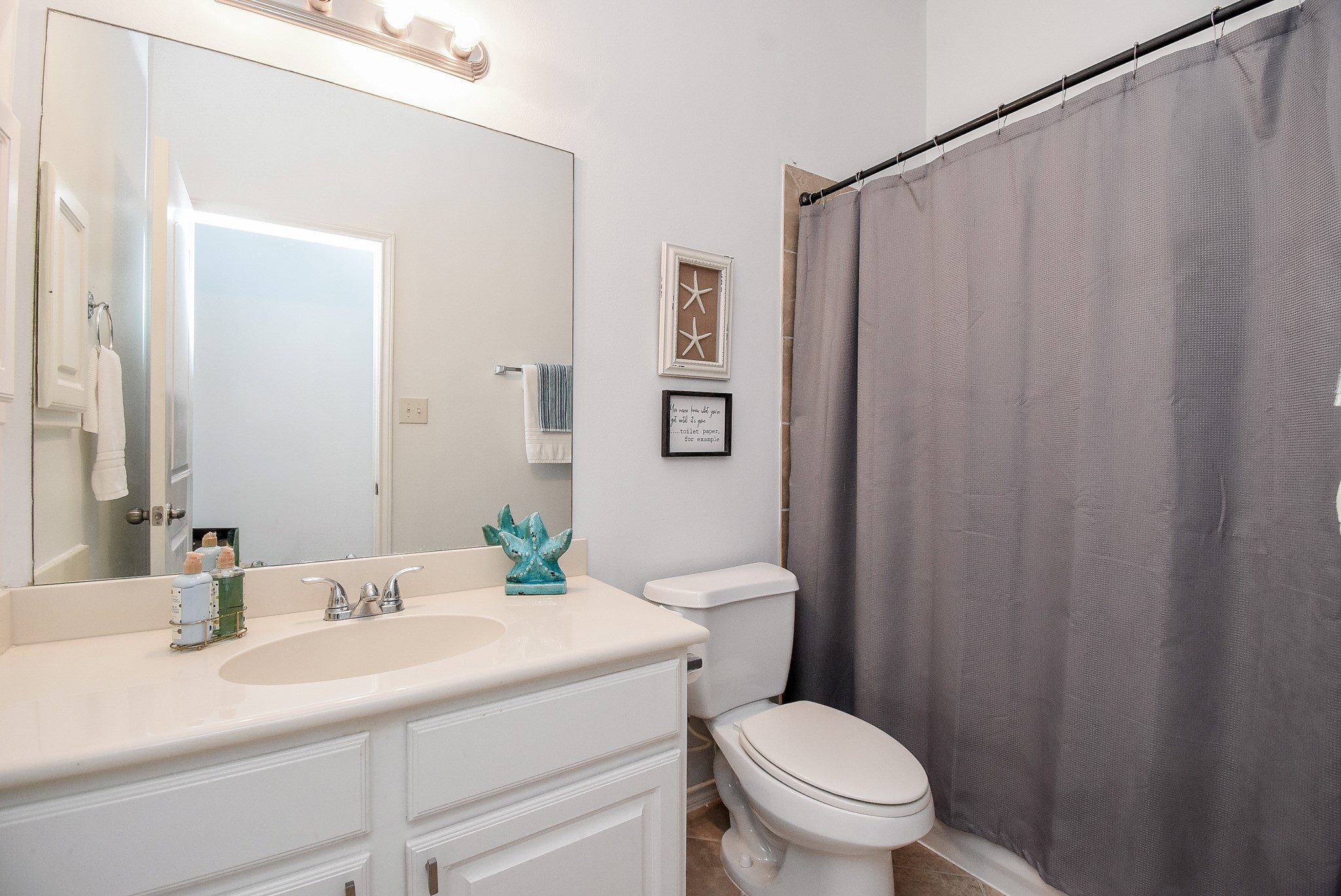 The second full bath has cabinet storage and tile shower surround!