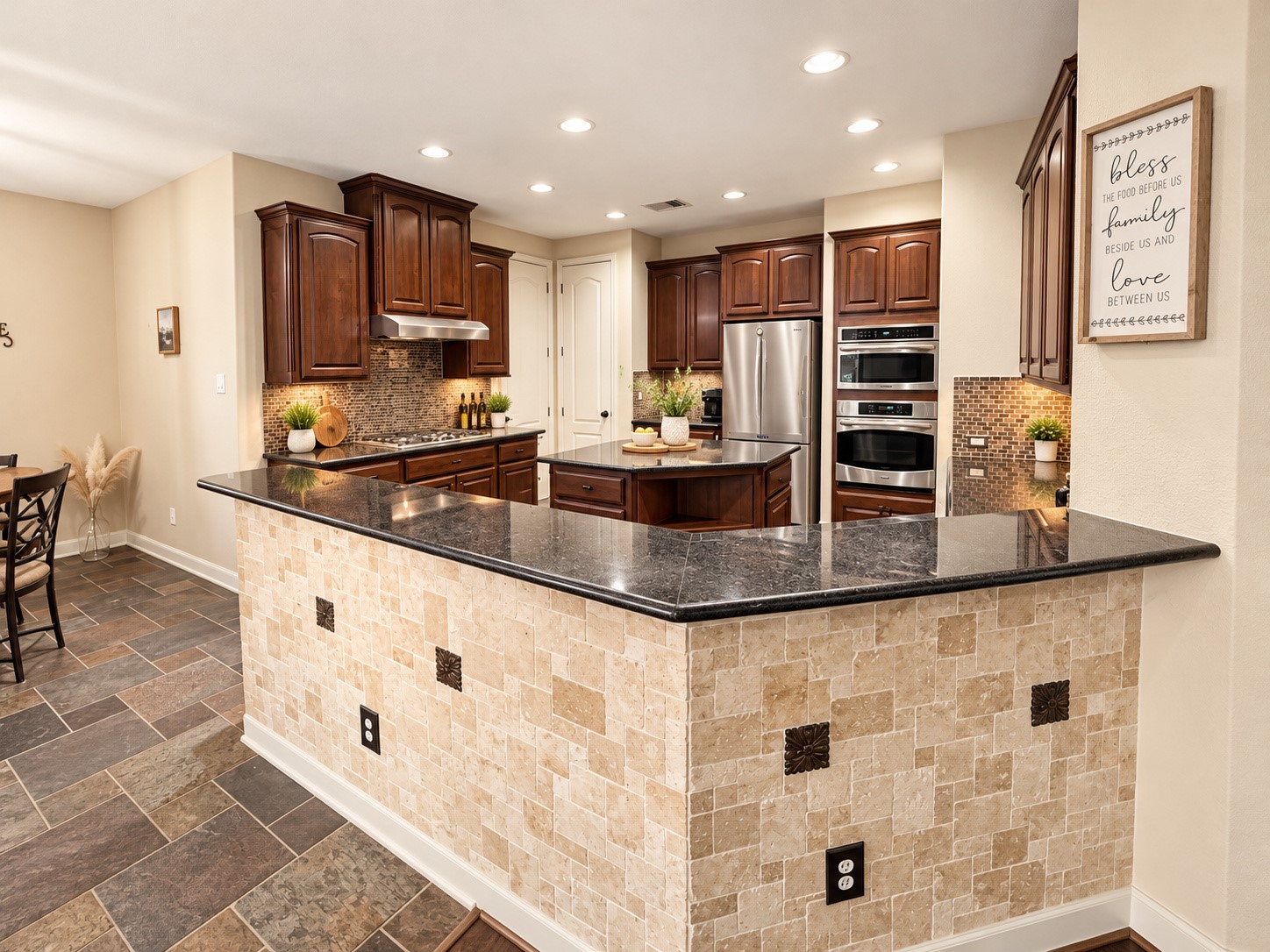 Convenient built-in serving area features rich cabinetry, dark countertops, and decorative tile backsplash.