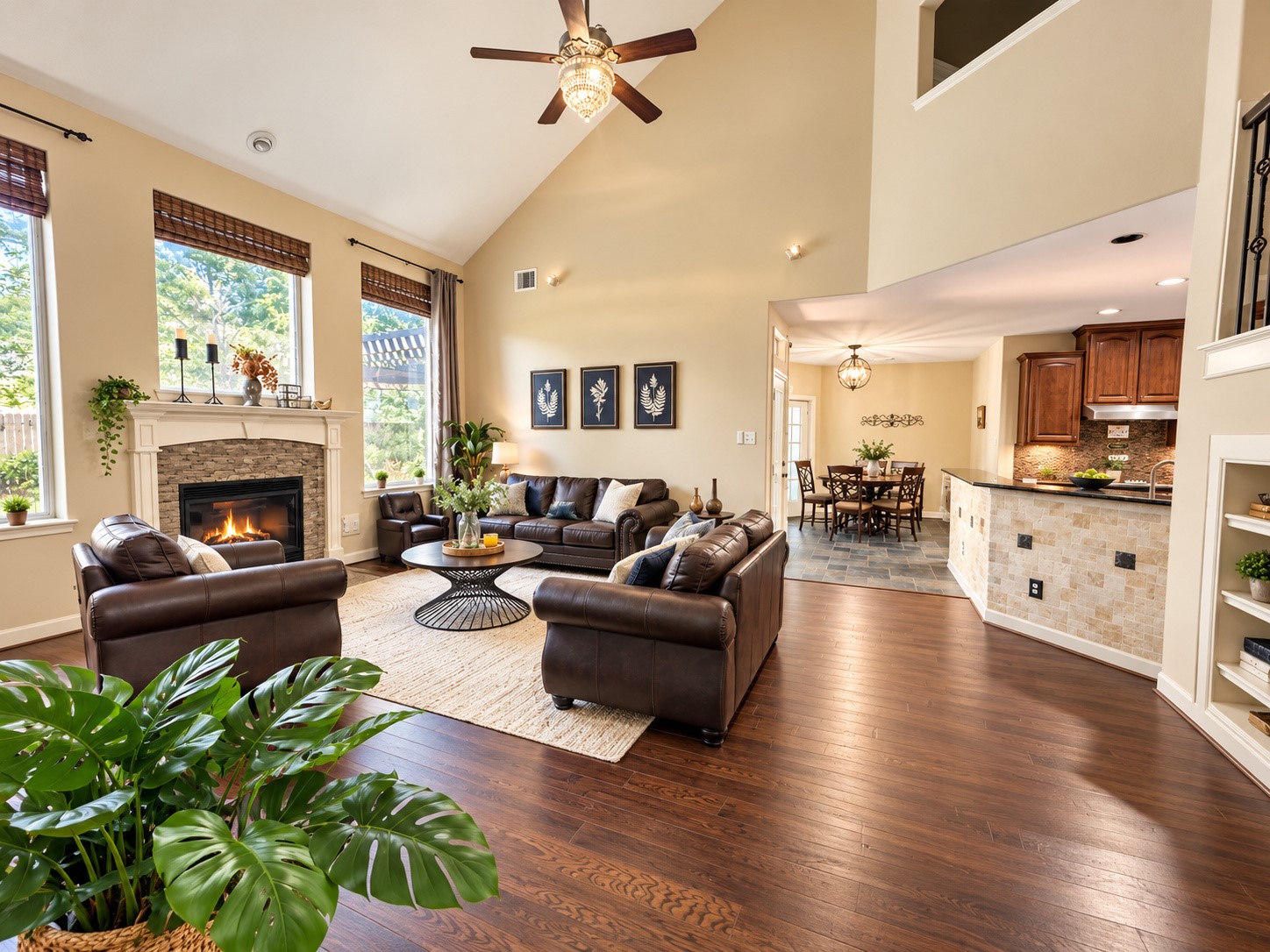 Dramatic family room with soaring ceilings, rich wood flooring, and a beautiful fireplace.