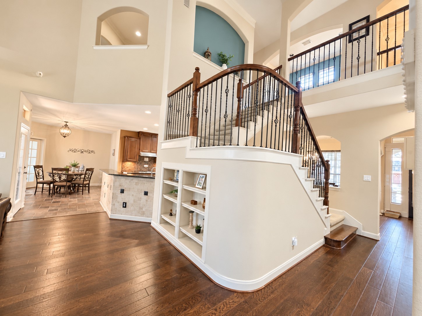 Elegant staircase with decorative wrought-iron balusters, rich wood railings, and carpeted steps.