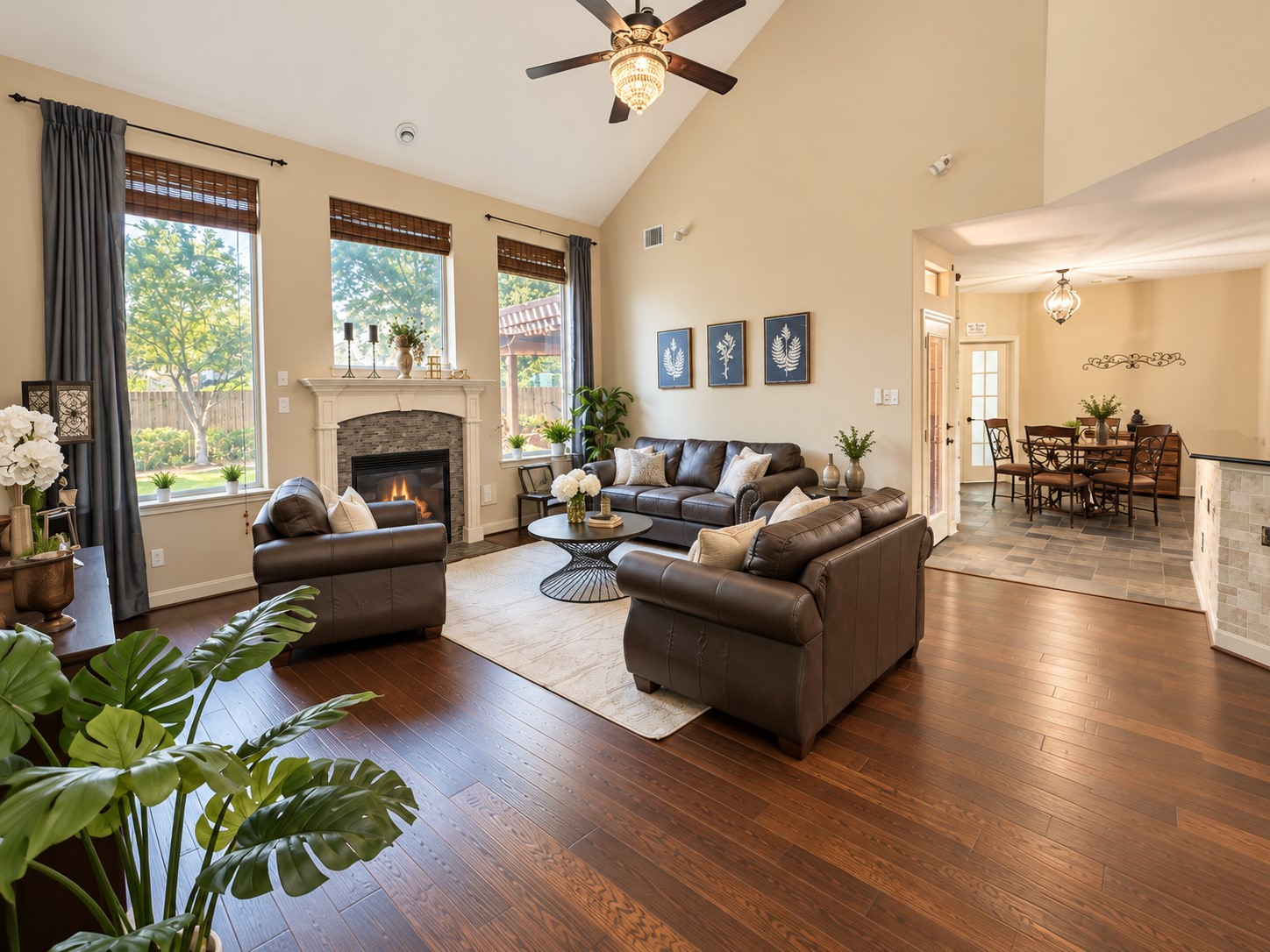 Dramatic family room with soaring ceilings, rich wood flooring, and a beautiful fireplace.