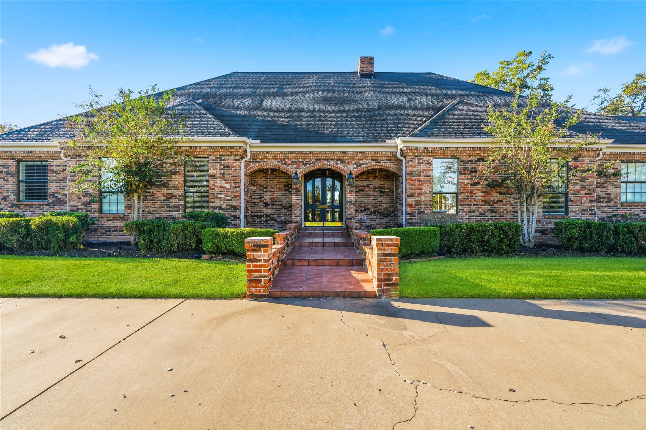 Stunning single-story brick home with manicured landscaping, inviting entrance, and classic architectural details.