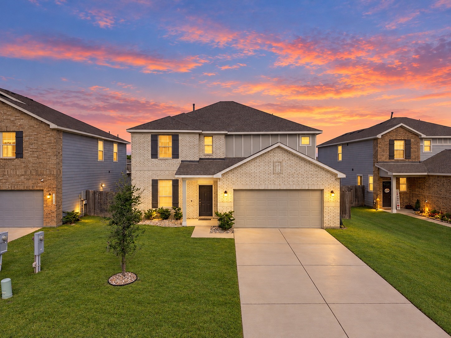 This beautiful two-story home showcases impressive curb appeal with a timeless brick exterior, contrasting dark shutters, and charming architectural details. A welcoming covered front entry adds character, while the attached two-car garage and wide concrete driveway provide ample parking space.