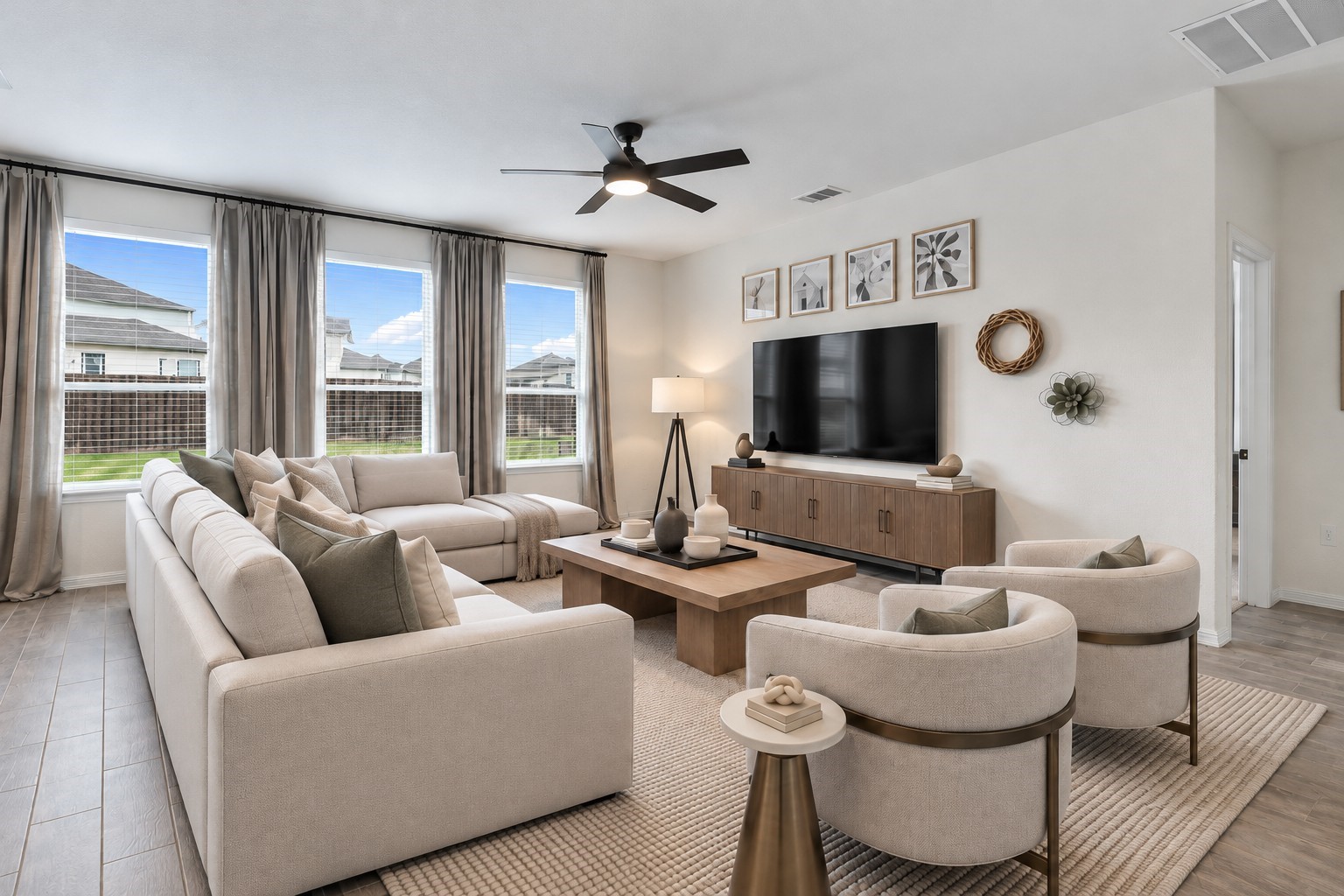 Virtually Staged: This bright and spacious living room features three large windows that fill the space with abundant natural light and offer views of the backyard. Beautiful wood-look tile flooring extends throughout the room, complementing the soft neutral wall tones and creating a clean, contemporary atmosphere.