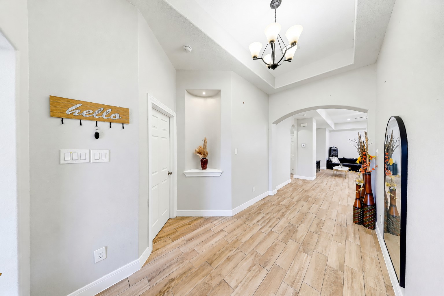Welcome guests through a lofty foyer with graceful arches and wood-look tile.