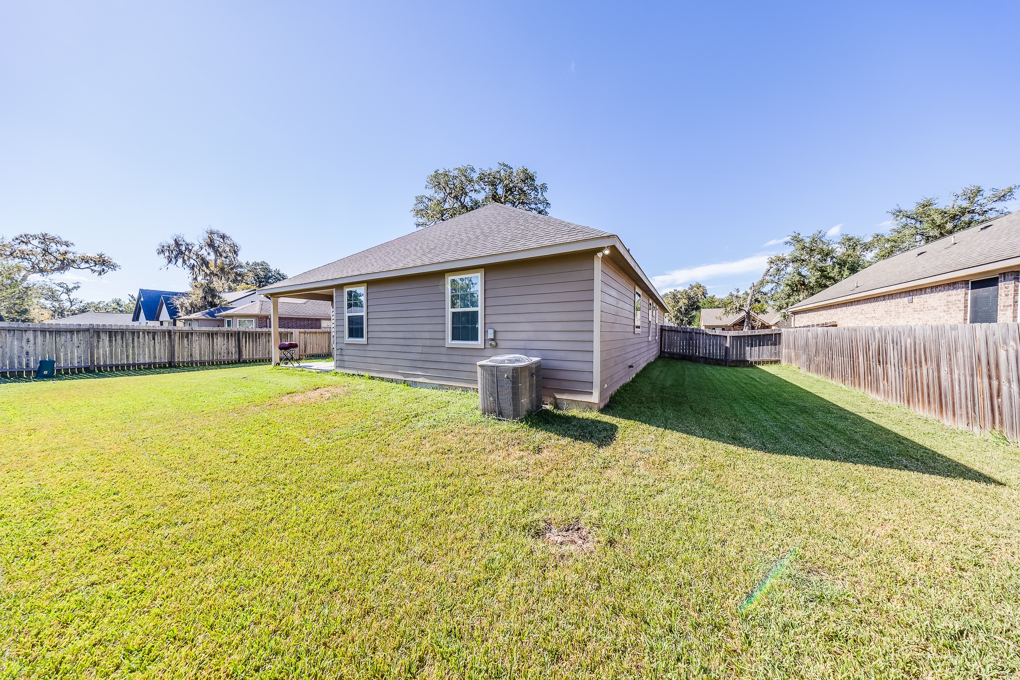 Make room for outdoor fun in a spacious backyard with a covered spot to relax.